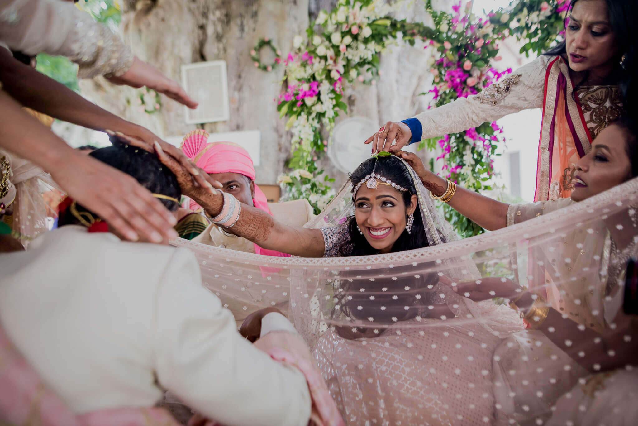 Anu & Raghu celebrate with family around polka-dot veil, floral backdrop, Nepal wedding
