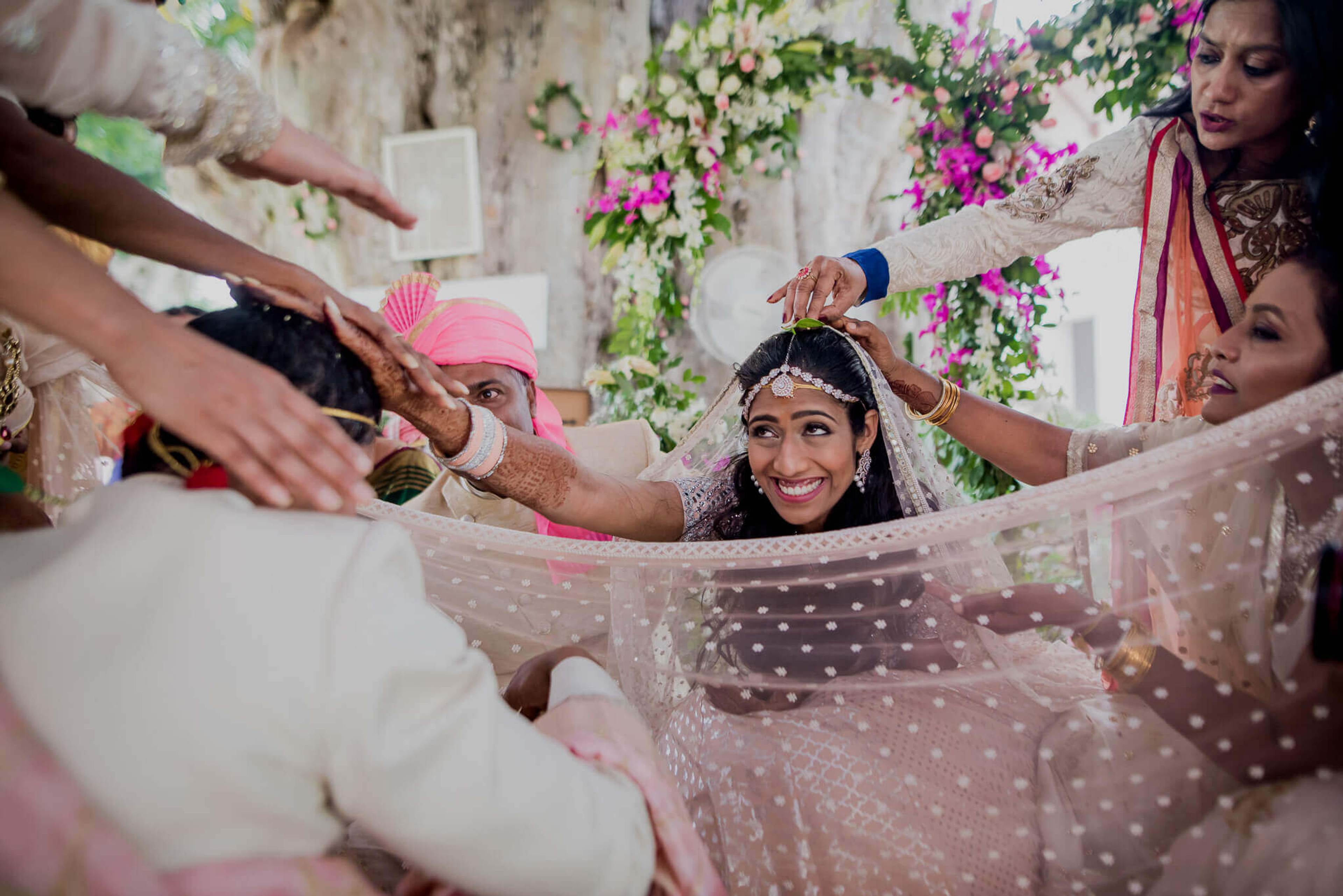 Anu & Raghu celebrate with family around polka-dot veil, floral backdrop, Nepal wedding