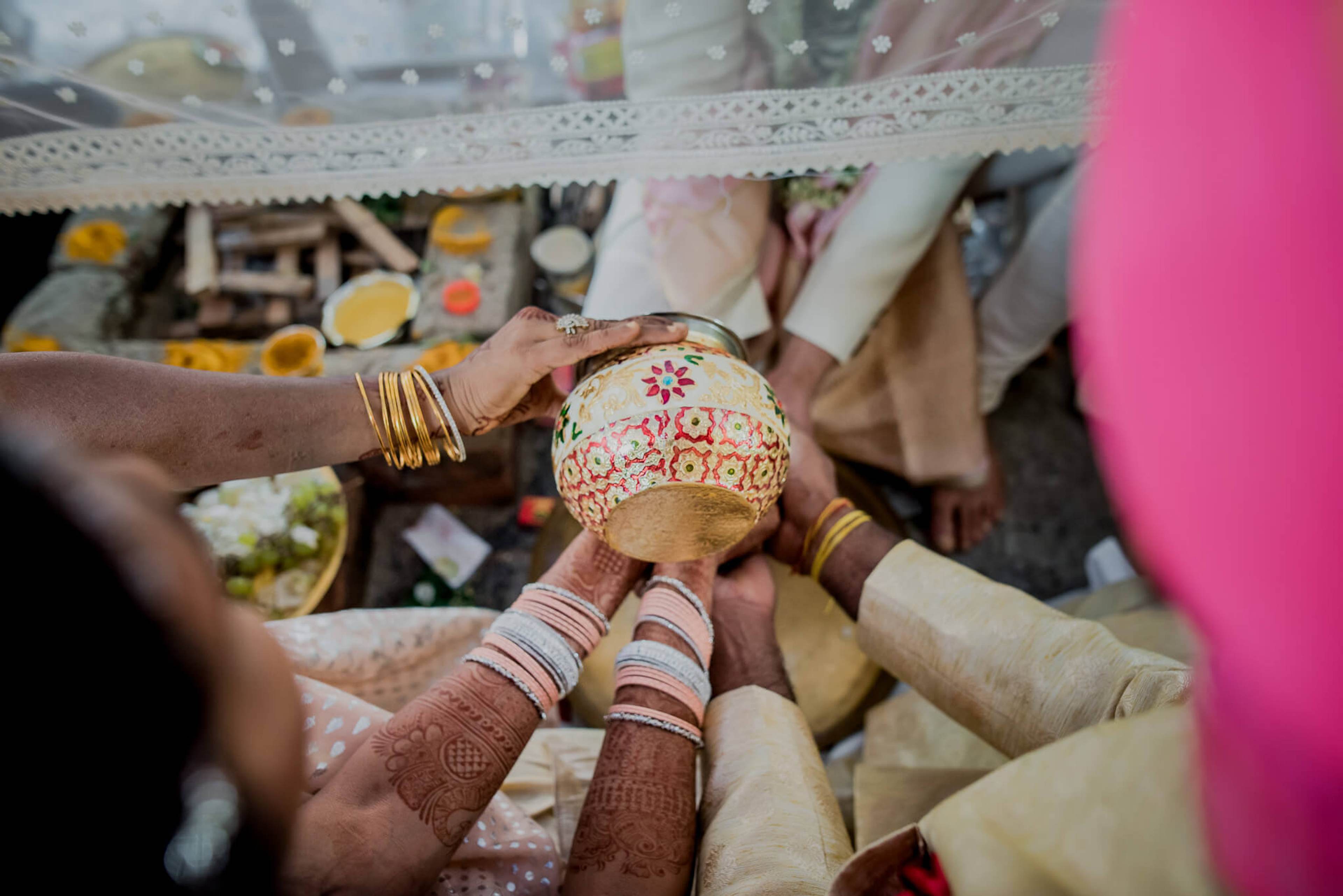 Anu and Raghu's hands hold decorated coconut during wedding ceremony in Nepal