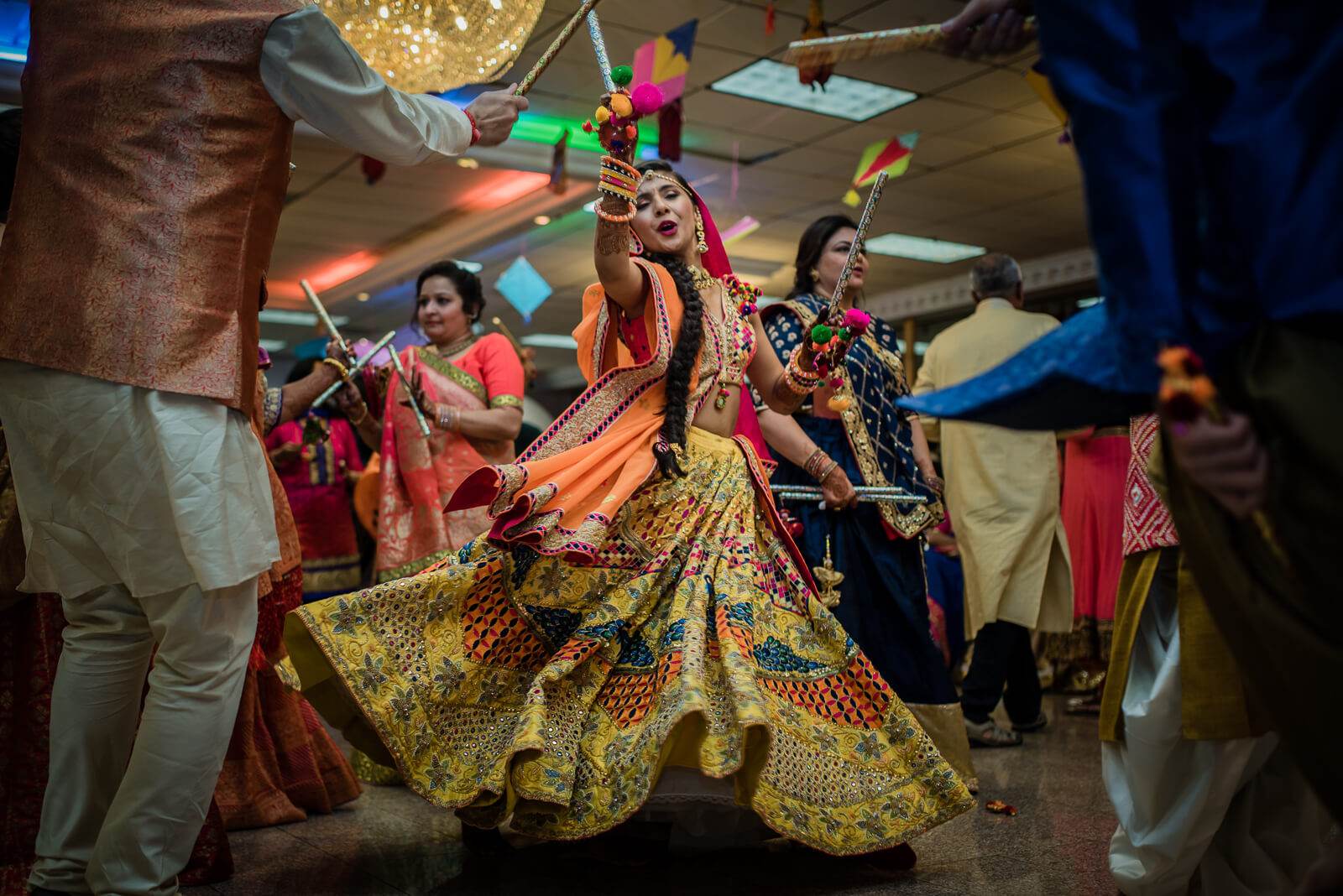 Barkha twirls in vibrant yellow lehenga, ornate jewelry gleams under warm indoor lighting at celebration