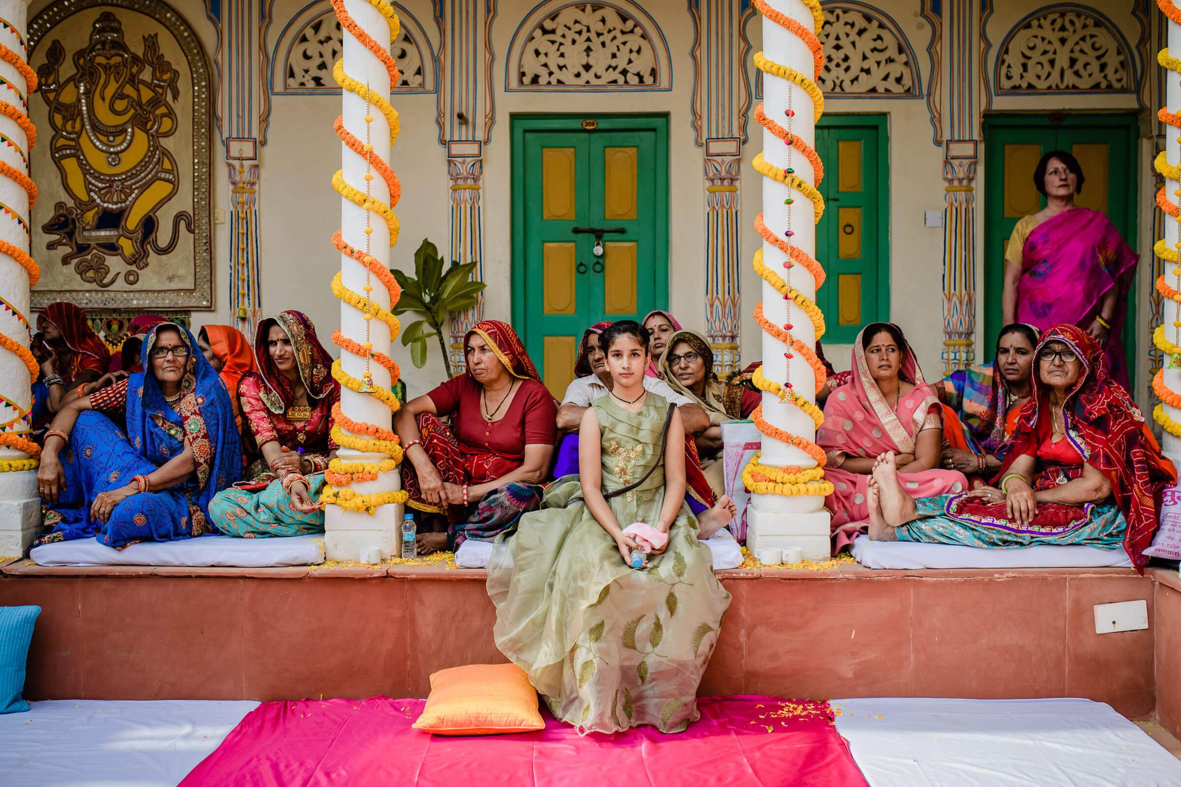 Maitrayee and Eric's wedding celebrations in Rajasthan, with family and friends seated before ornate temple doors