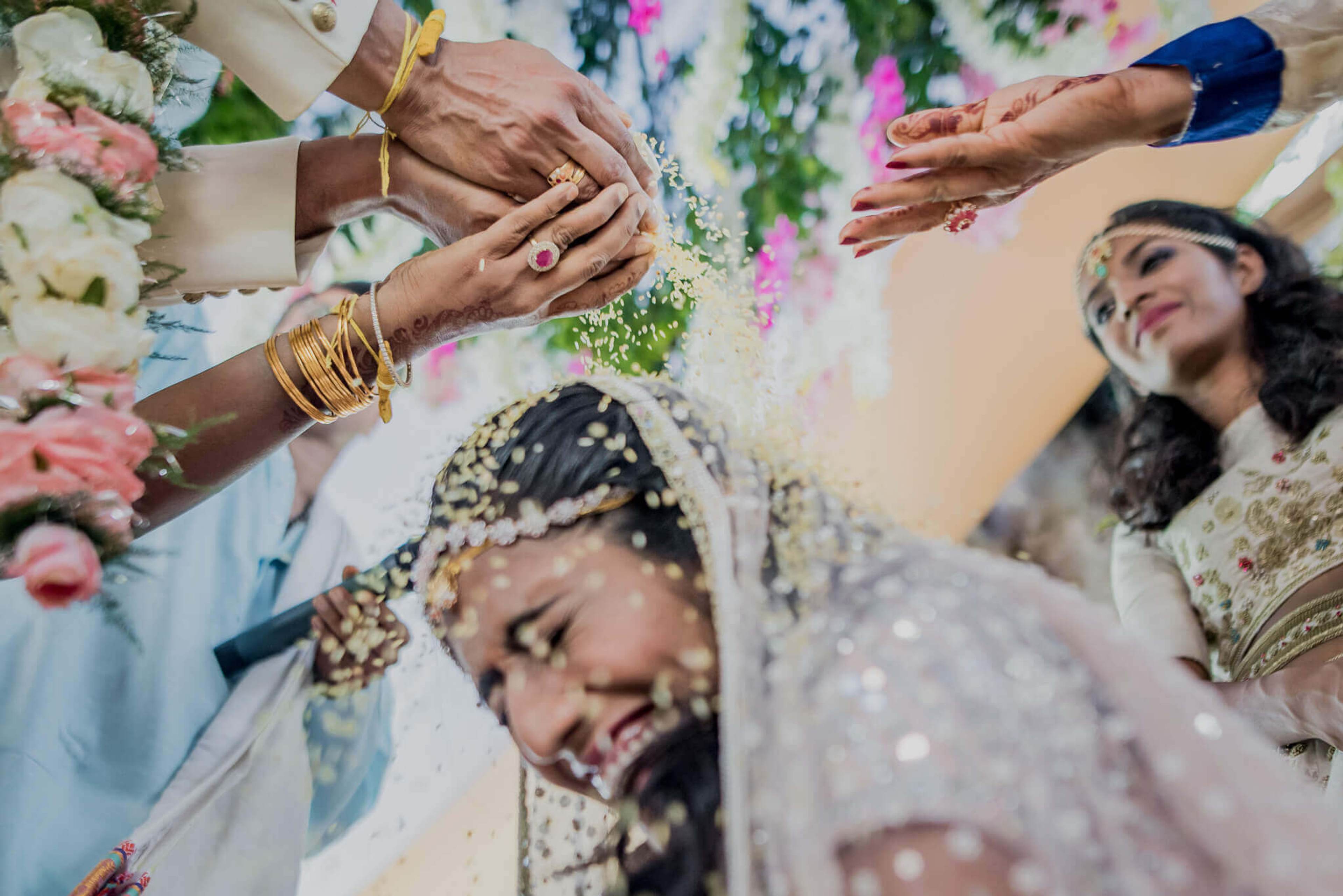 Anu and Raghu's hands adorned with jewelry and flowers during wedding ceremony in Nepal
