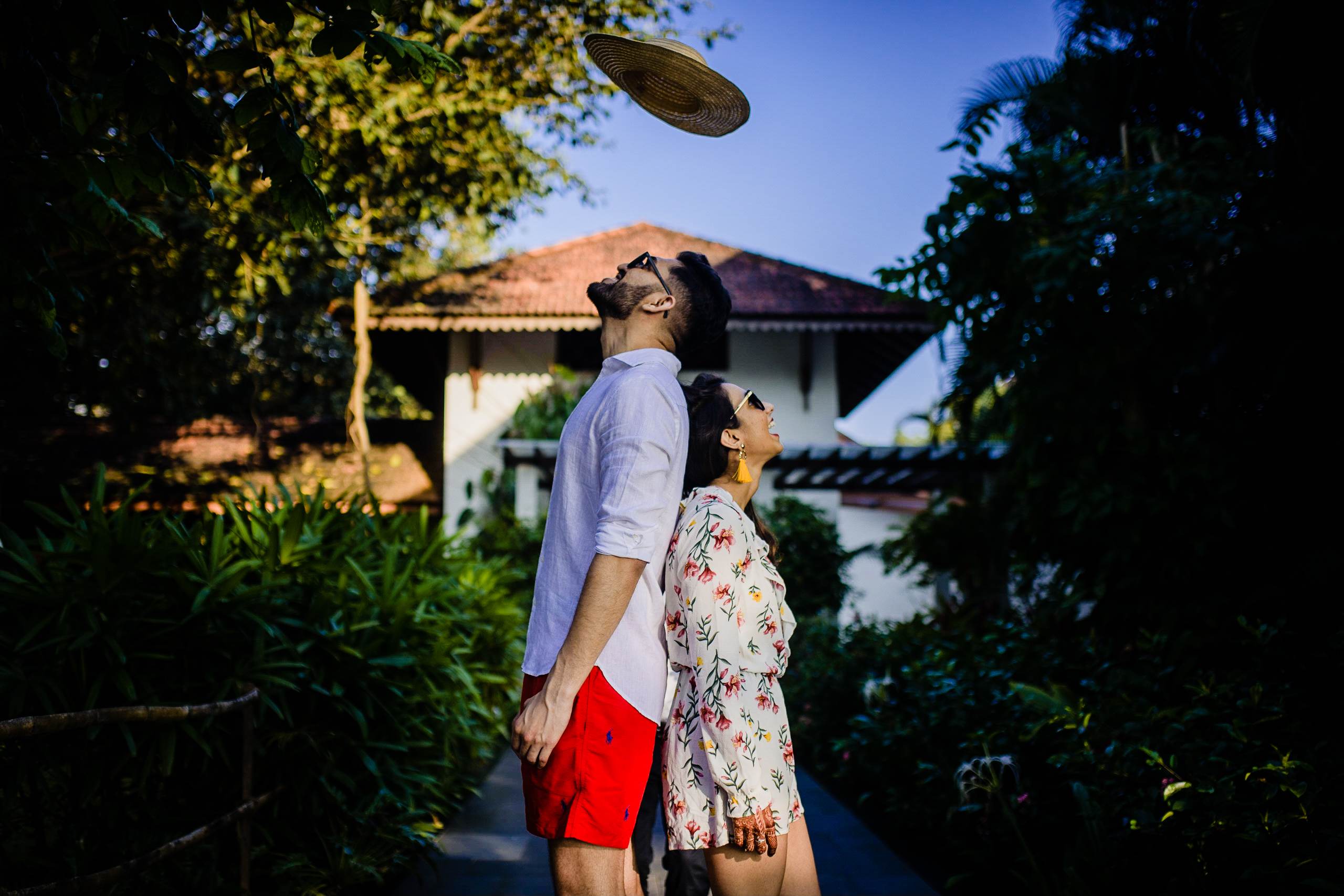 Avani and Srikant play frisbee in lush gardens, colonial villa visible behind them in Goa
