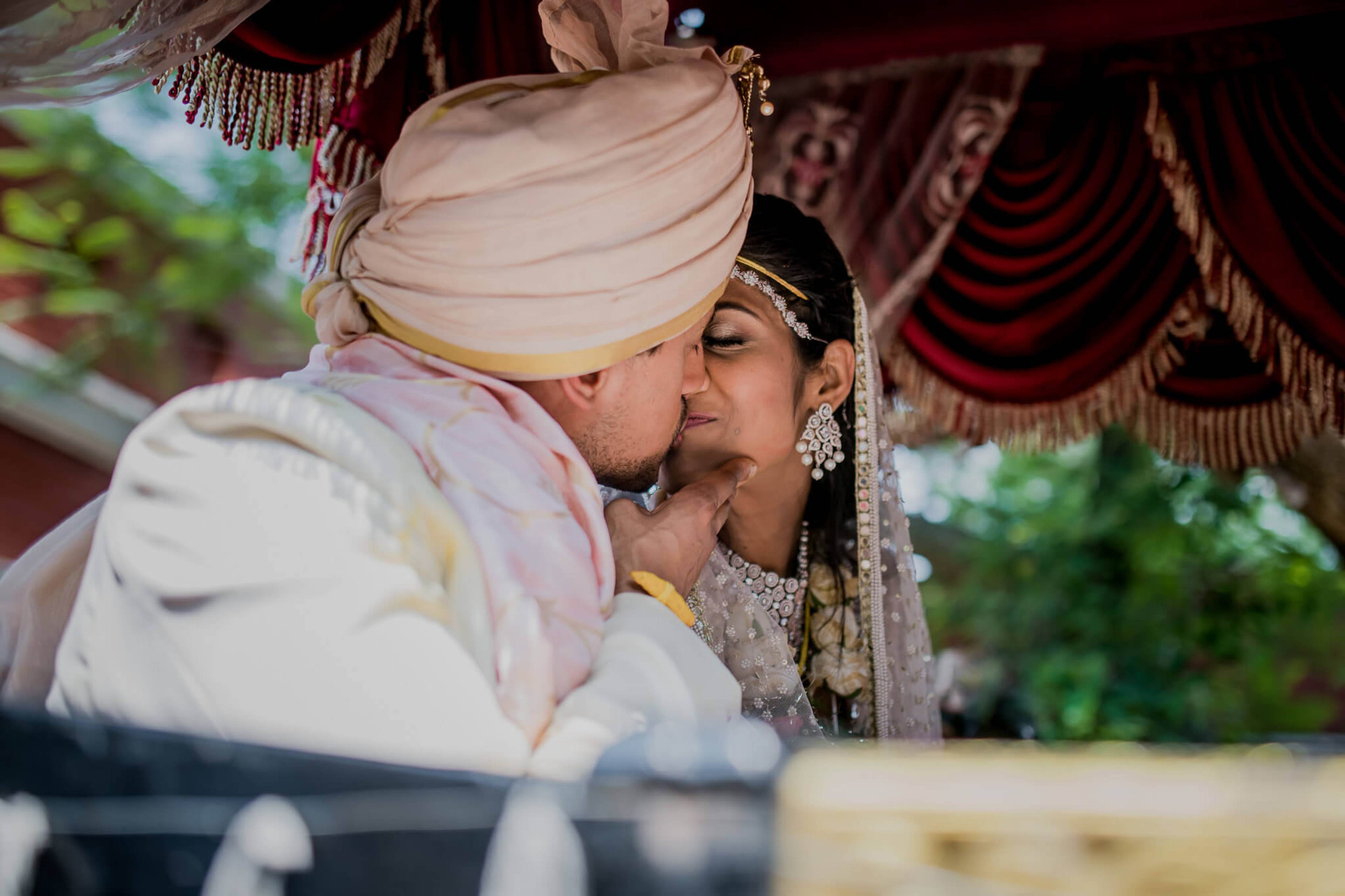 Anu and Raghu share an intimate moment under ornate red drapery during their Nepal wedding ceremony