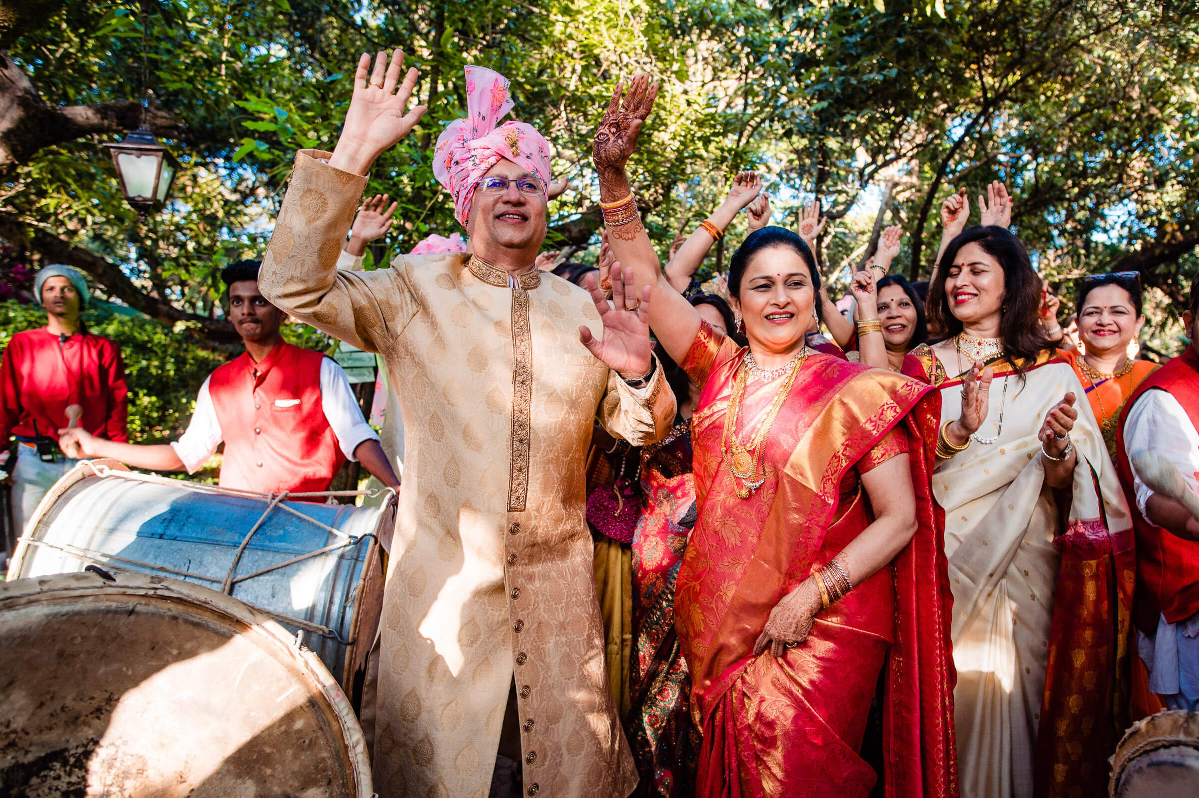 Shreya and Yash celebrate with family in traditional attire under dappled tree shade at Mahabaleshwar