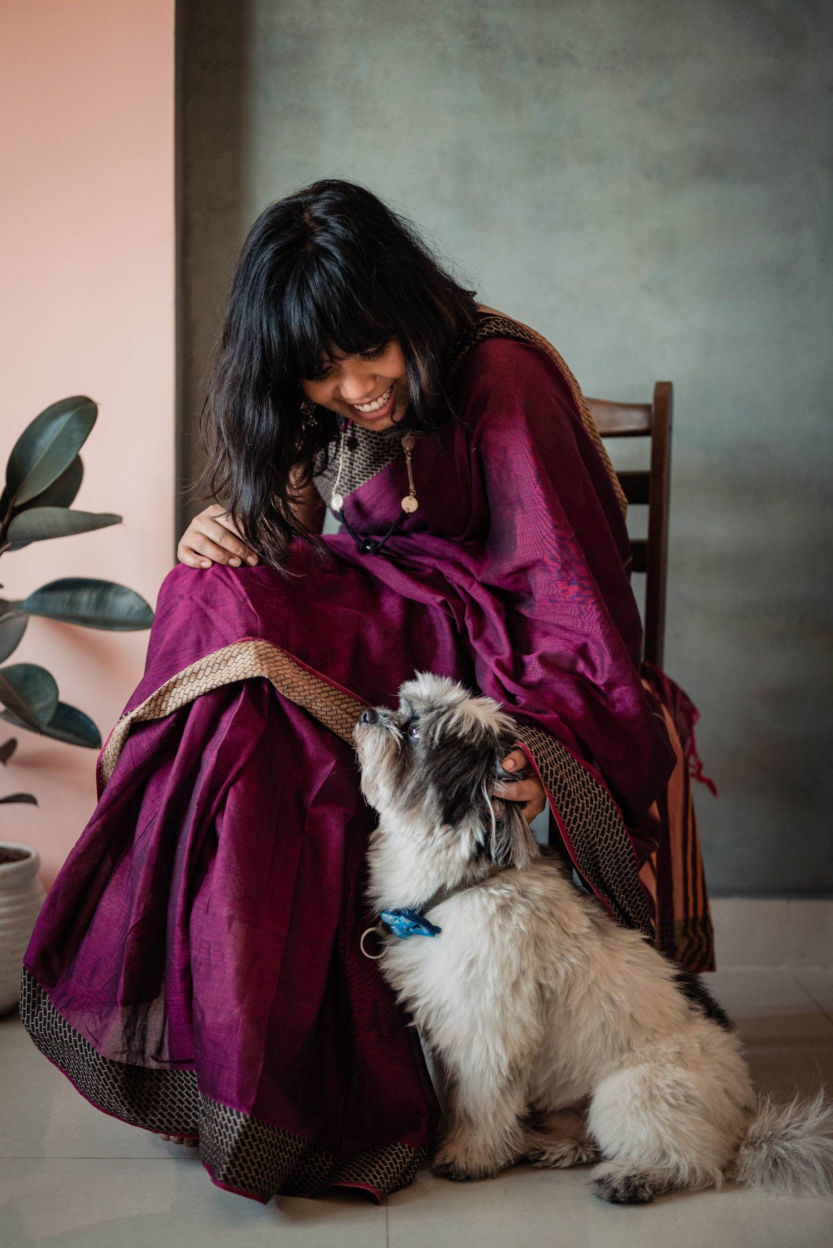 Rimi Sen in a maroon saree laughing with her dog Casper