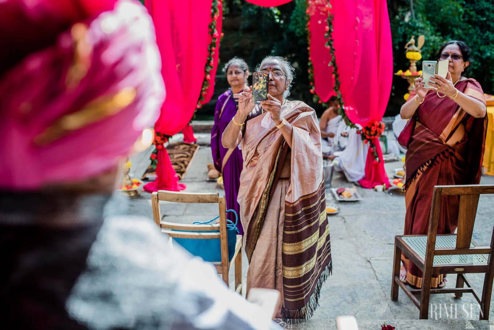 Guests in traditional attire celebrate under magenta draping at Pooja and Aniket's Bangalore wedding
