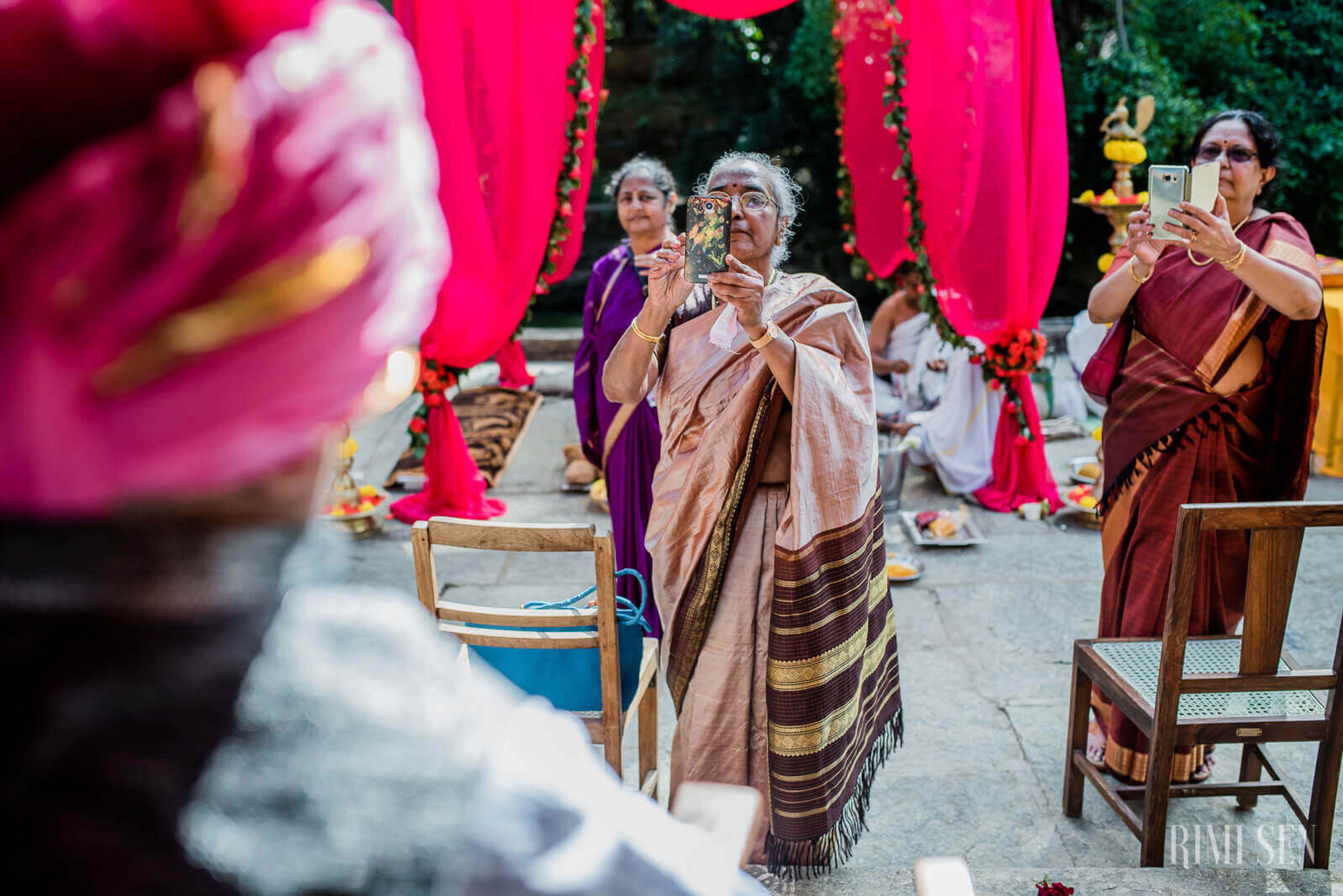Guests in traditional attire celebrate under magenta draping at Pooja and Aniket's Bangalore wedding
