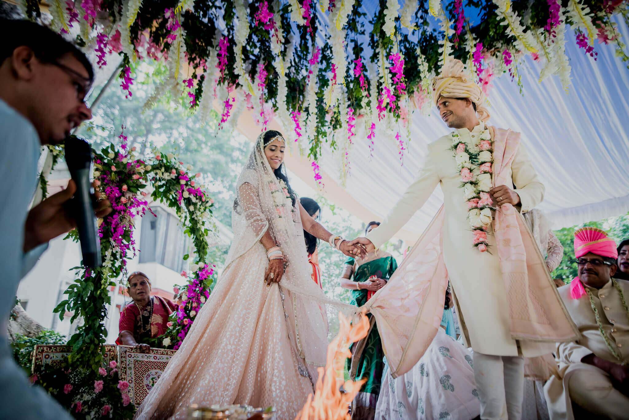 Anu and Raghu exchange hands under vibrant hanging flowers in their Nepal wedding ceremony