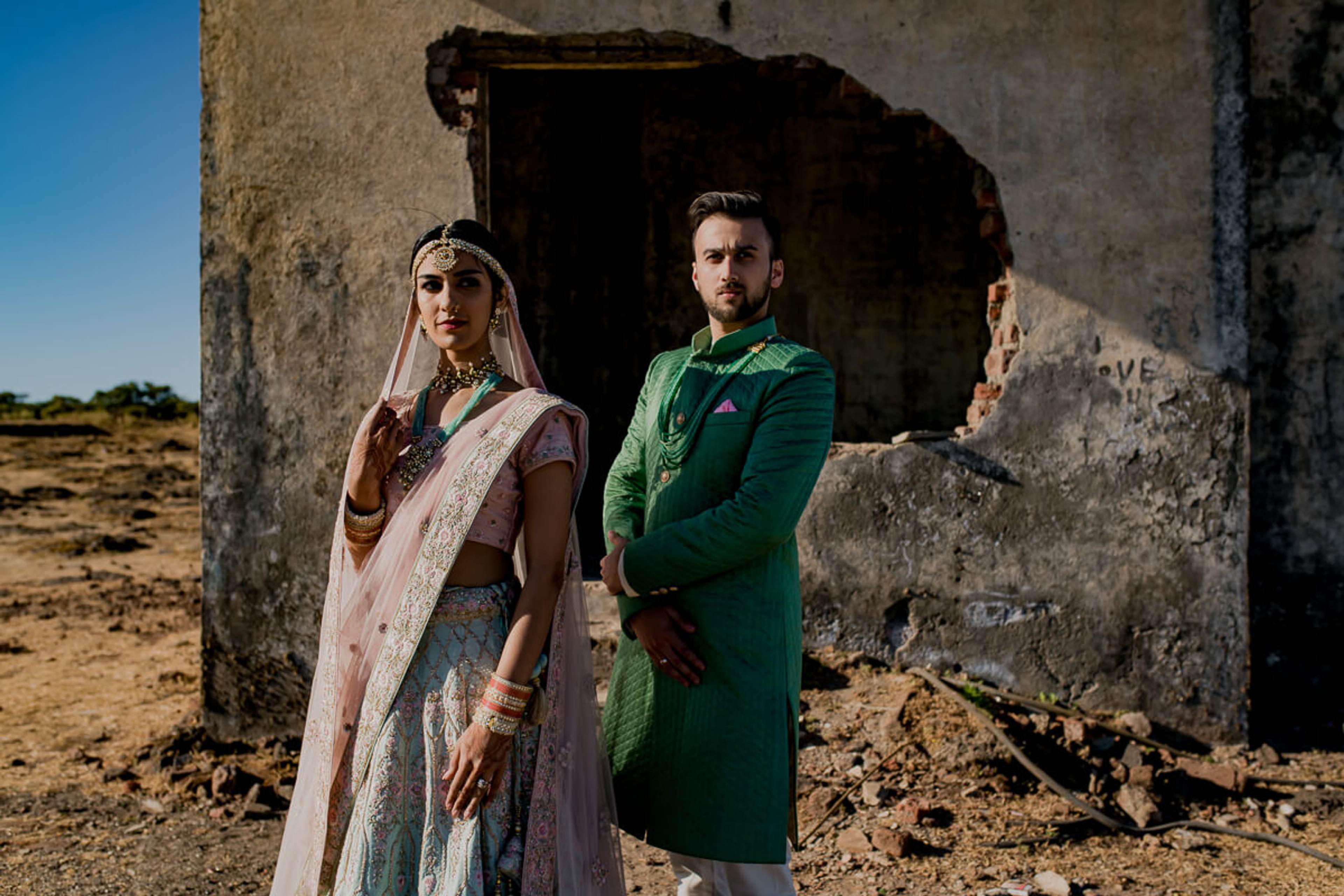 Shreya and Yash stand at a weathered stone doorway in Mahabaleshwar, wearing traditional attire