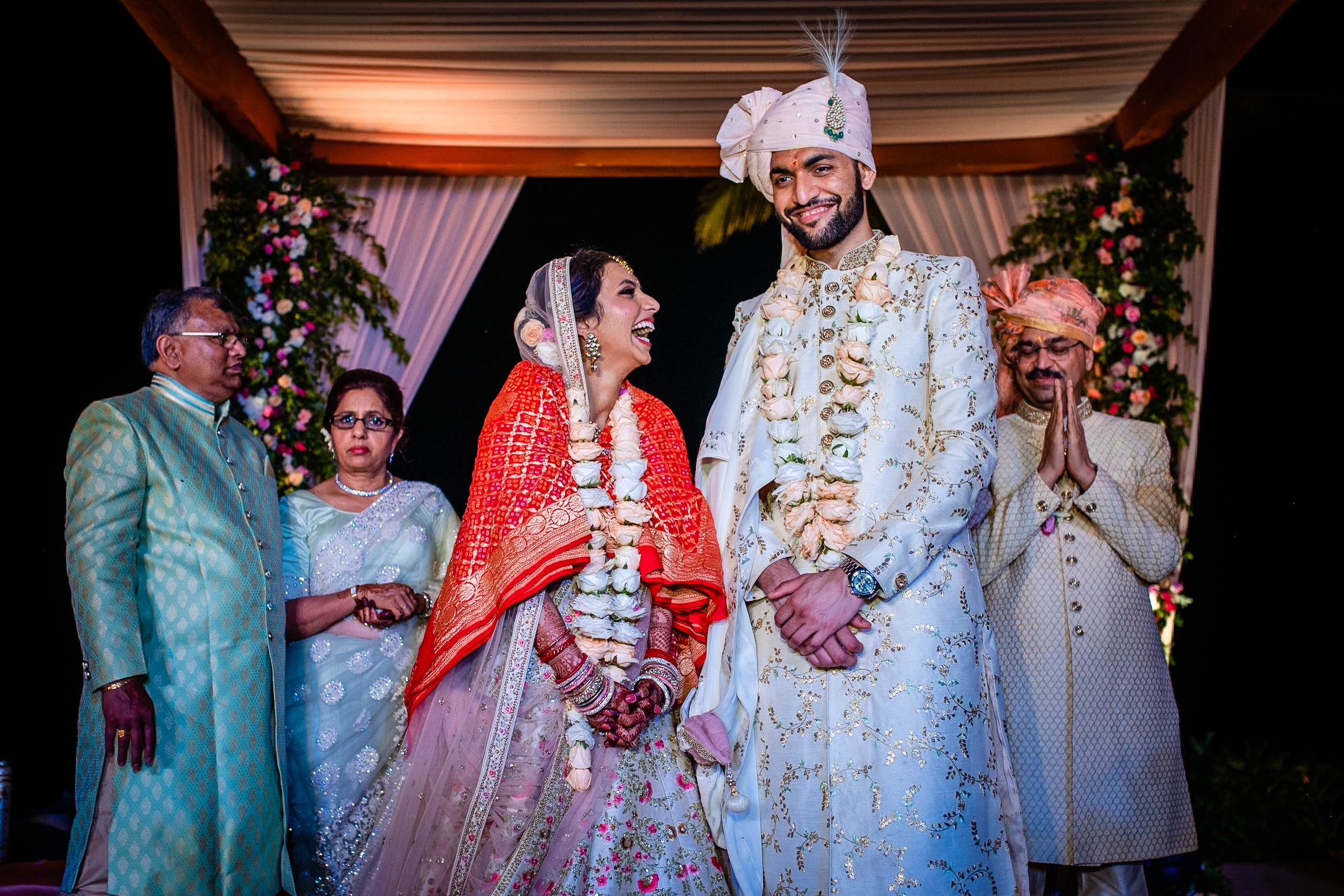 Avani and Srikant exchange vows in traditional Indian wedding attire under a floral-adorned canopy in Goa