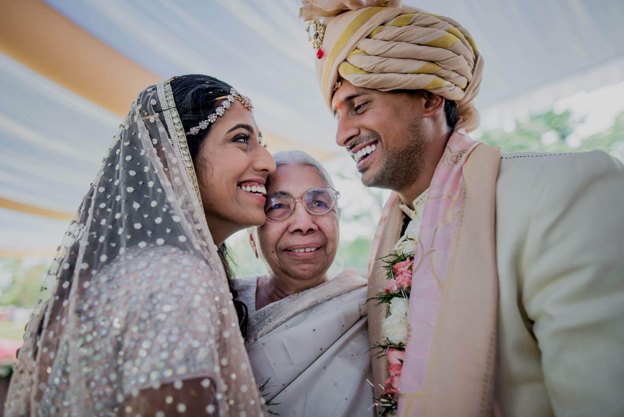 Anu and Raghu smile with an elder family member during their traditional wedding ceremony in Nepal