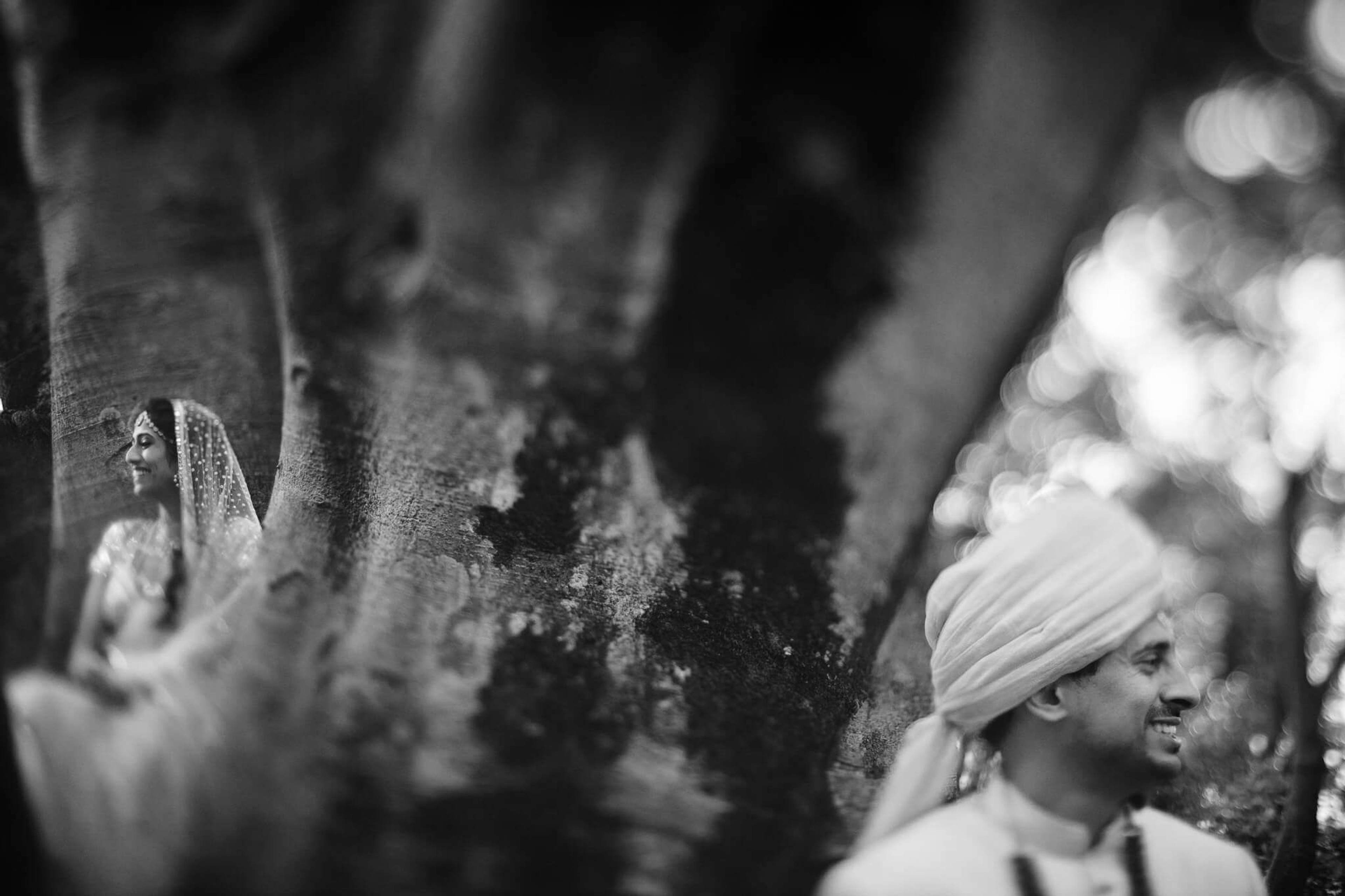 Anu and Raghu smile together in traditional attire during their Nepal wedding celebration, captured in soft black and white