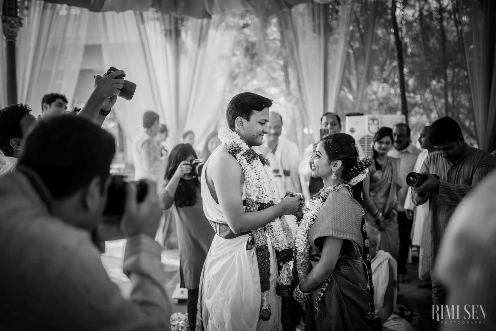 Pooja and Aniket dancing together surrounded by guests and photographers under sheer drapes at their Bangalore wedding
