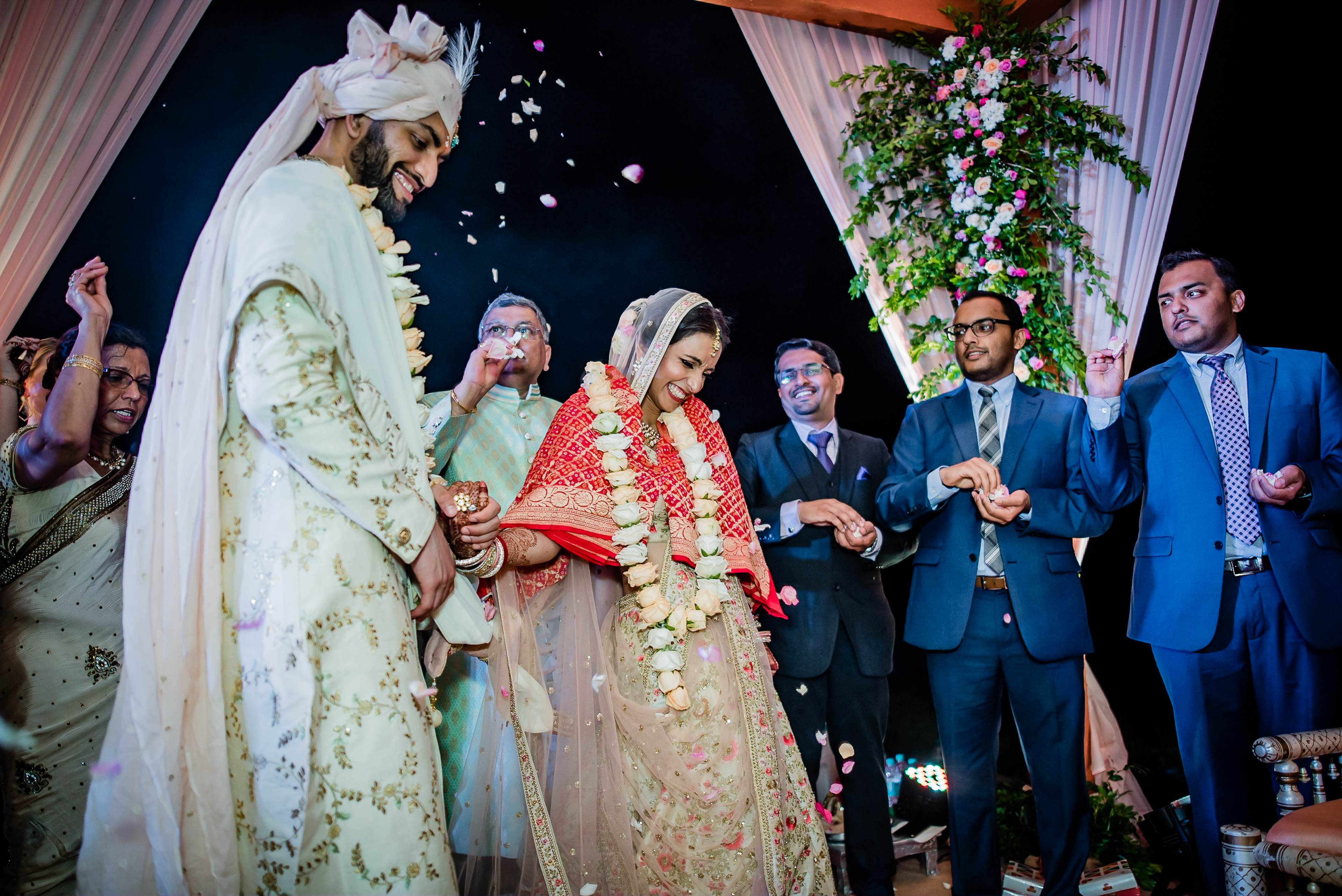 Avani and Srikant exchange flower garlands during wedding ceremony in Goa, surrounded by guests