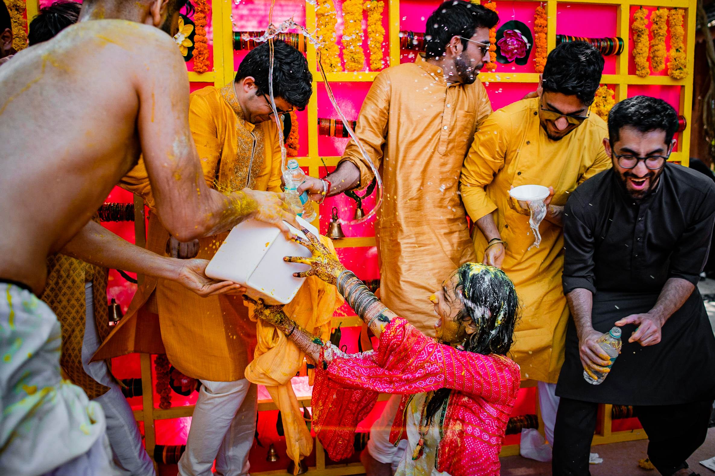 Avani & Srikant's wedding celebration in Goa with guests applying turmeric paste during colorful Haldi ceremony