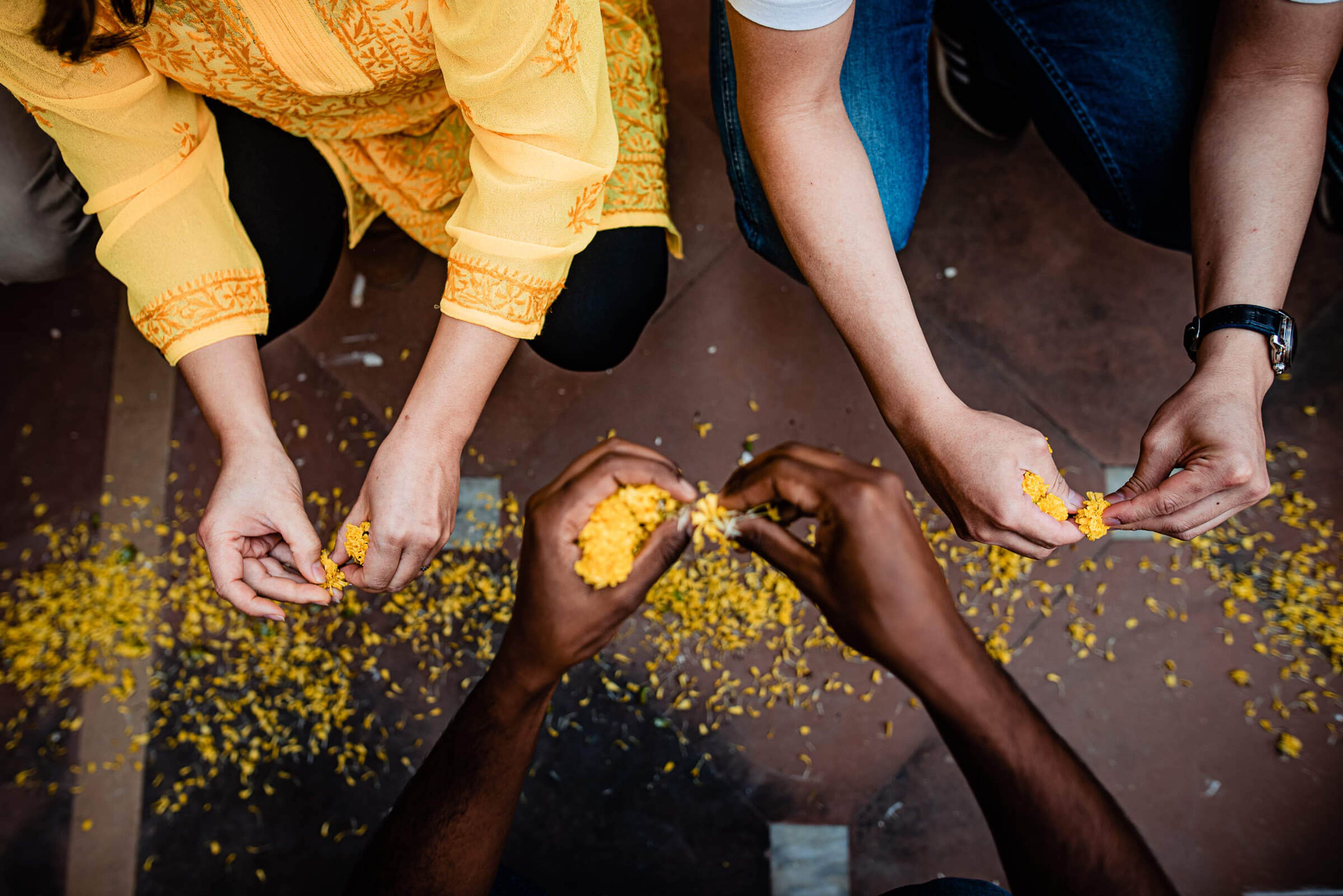 Maitrayee and Eric play with yellow flowers during Holi celebration in Rajasthan