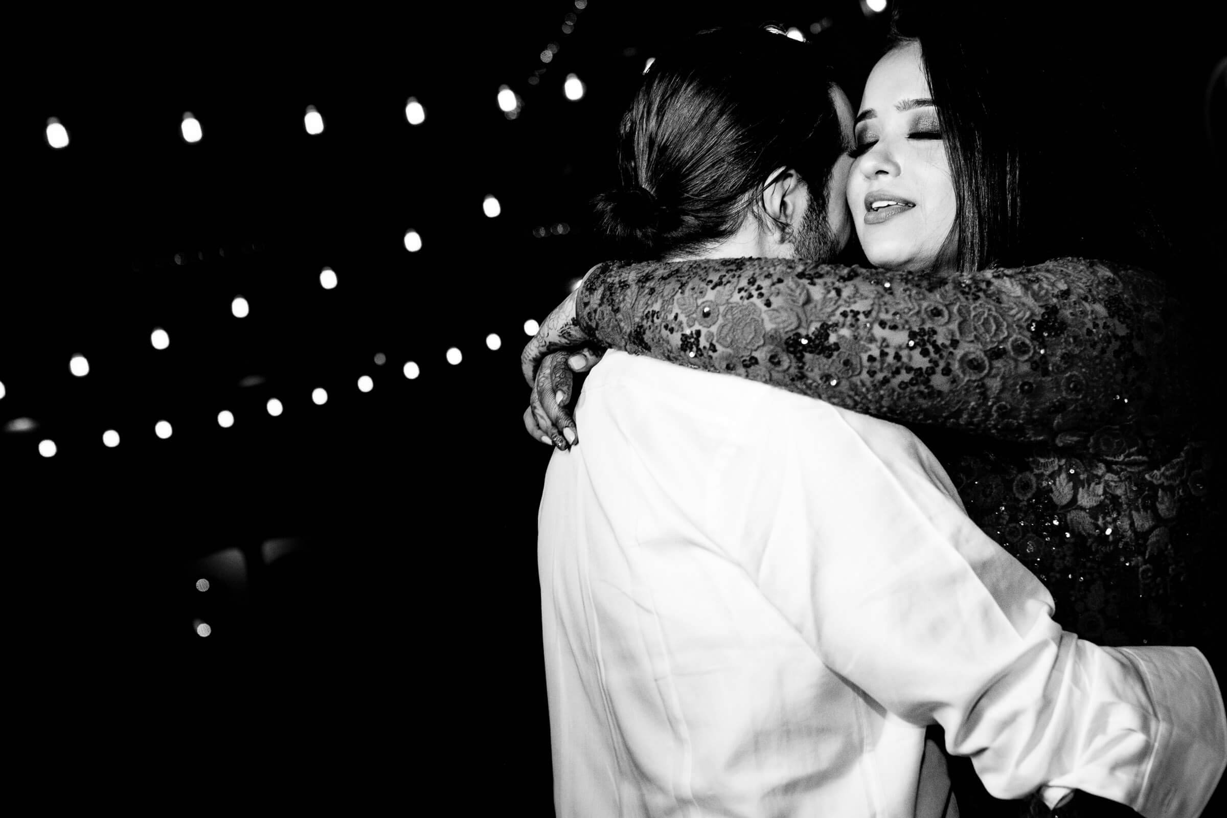 Maitrayee and Eric embrace under twinkling lights in black and white, Rajasthan