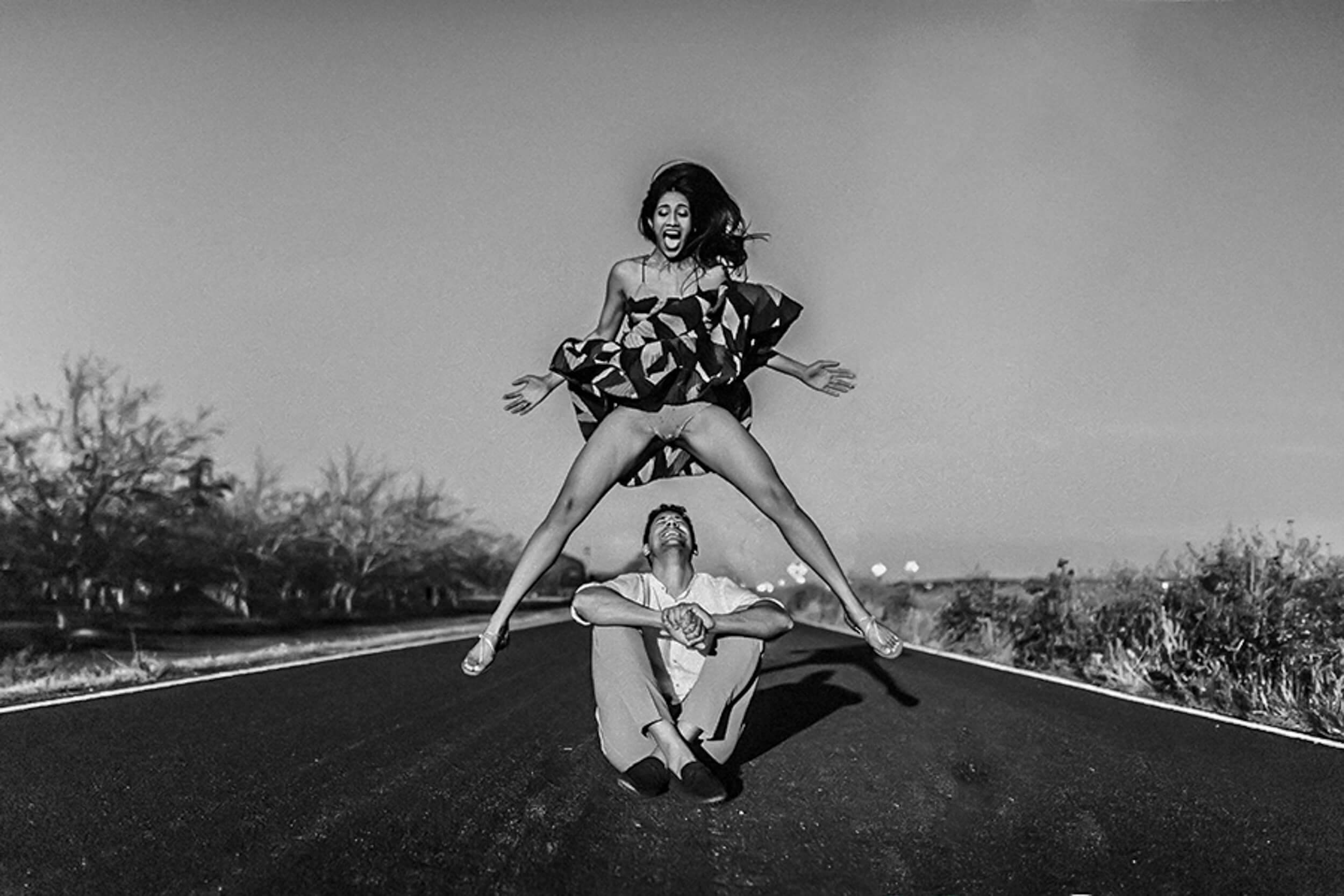 Anu and Raghu pose playfully on a California desert road in black and white