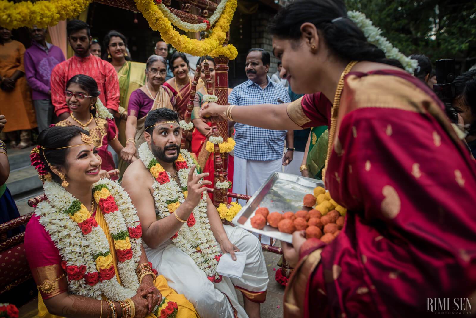 Nivetha and Sridhar exchange garlands at their Bangalore wedding ceremony surrounded by smiling family members