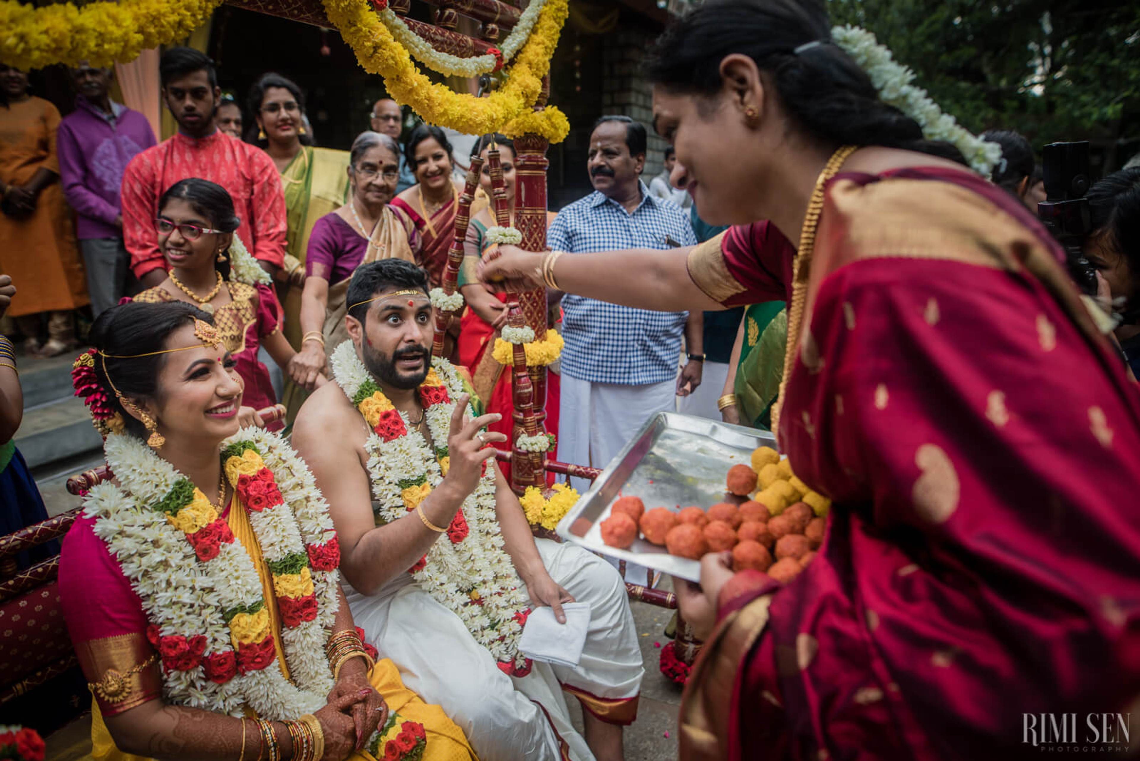 Nivetha and Sridhar exchange garlands at their Bangalore wedding ceremony surrounded by smiling family members