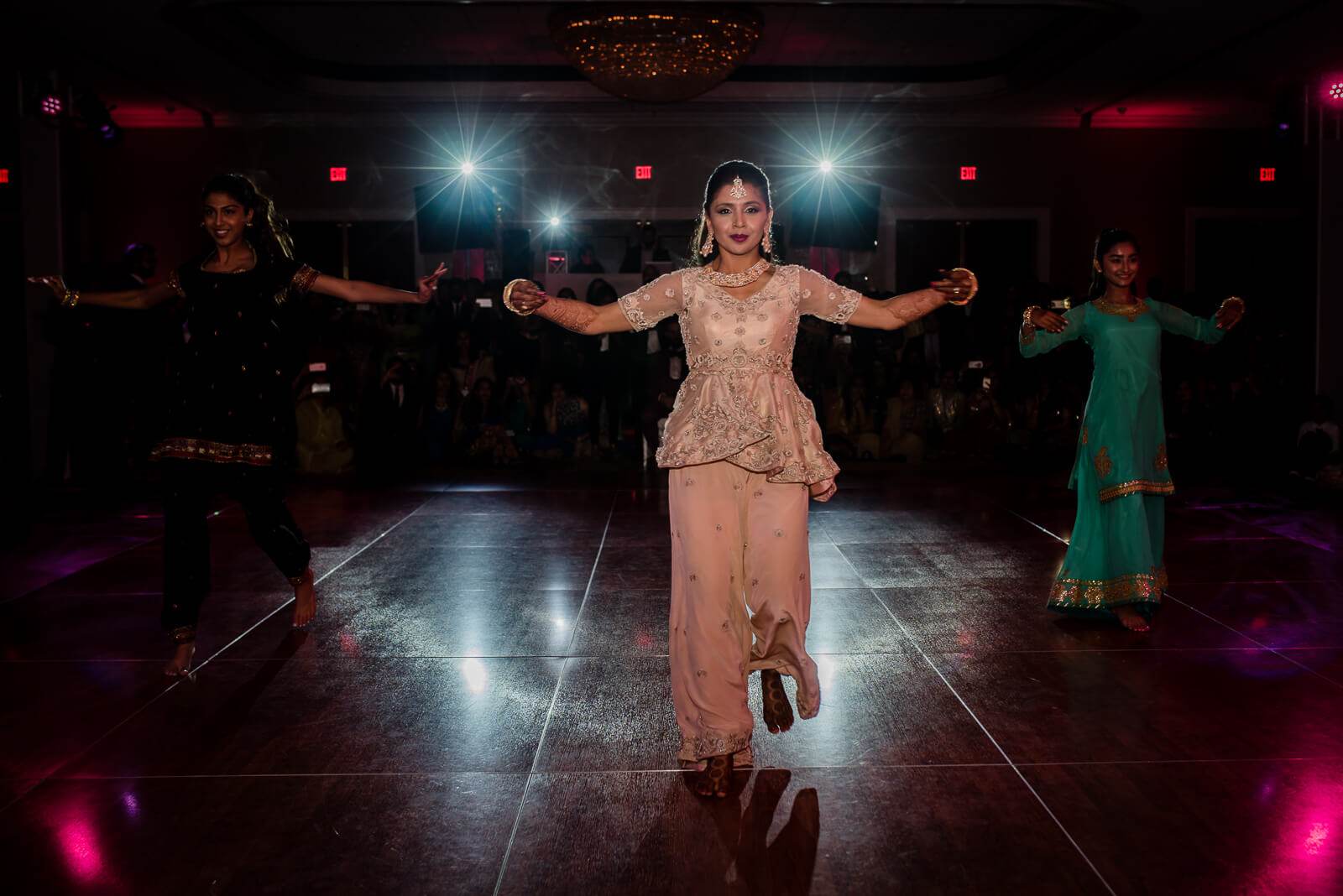 Barkha dancing with arms outstretched on lit ballroom floor at New York reception, guests surrounding in vibrant evening wear