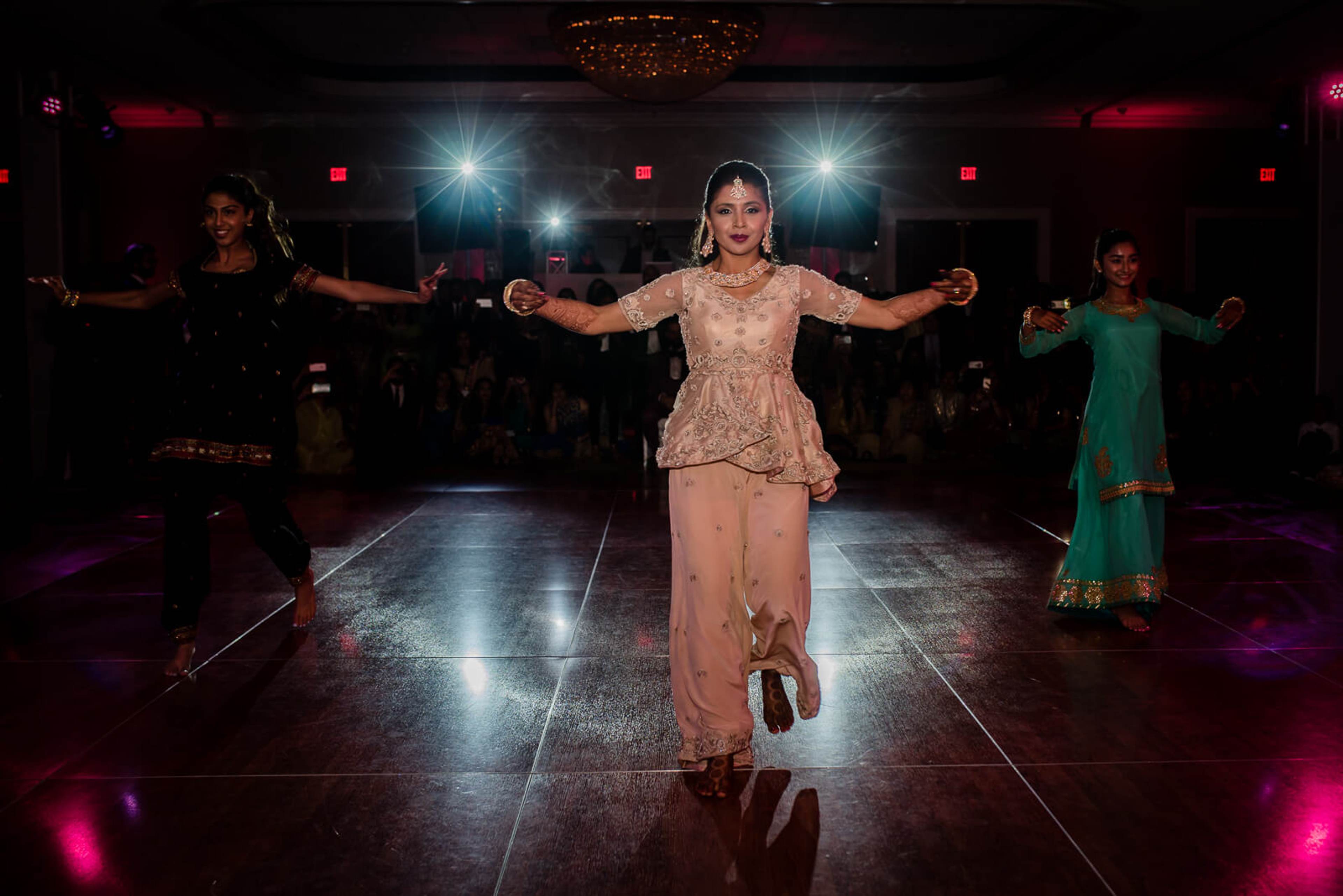 Barkha dancing with arms outstretched on lit ballroom floor at New York reception, guests surrounding in vibrant evening wear