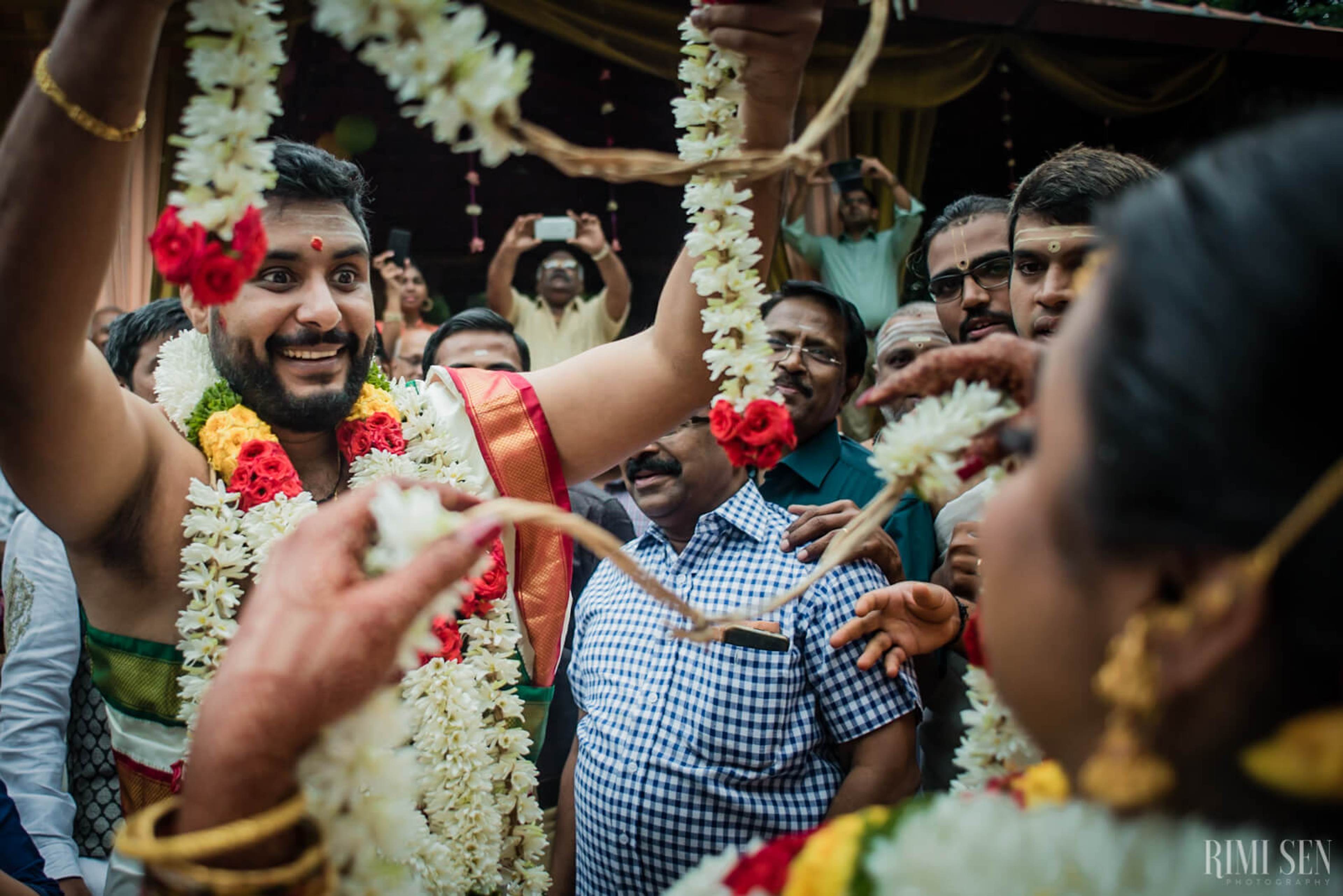 Groom Sridhar celebrates surrounded by guests in vibrant flower garlands at Bangalore wedding