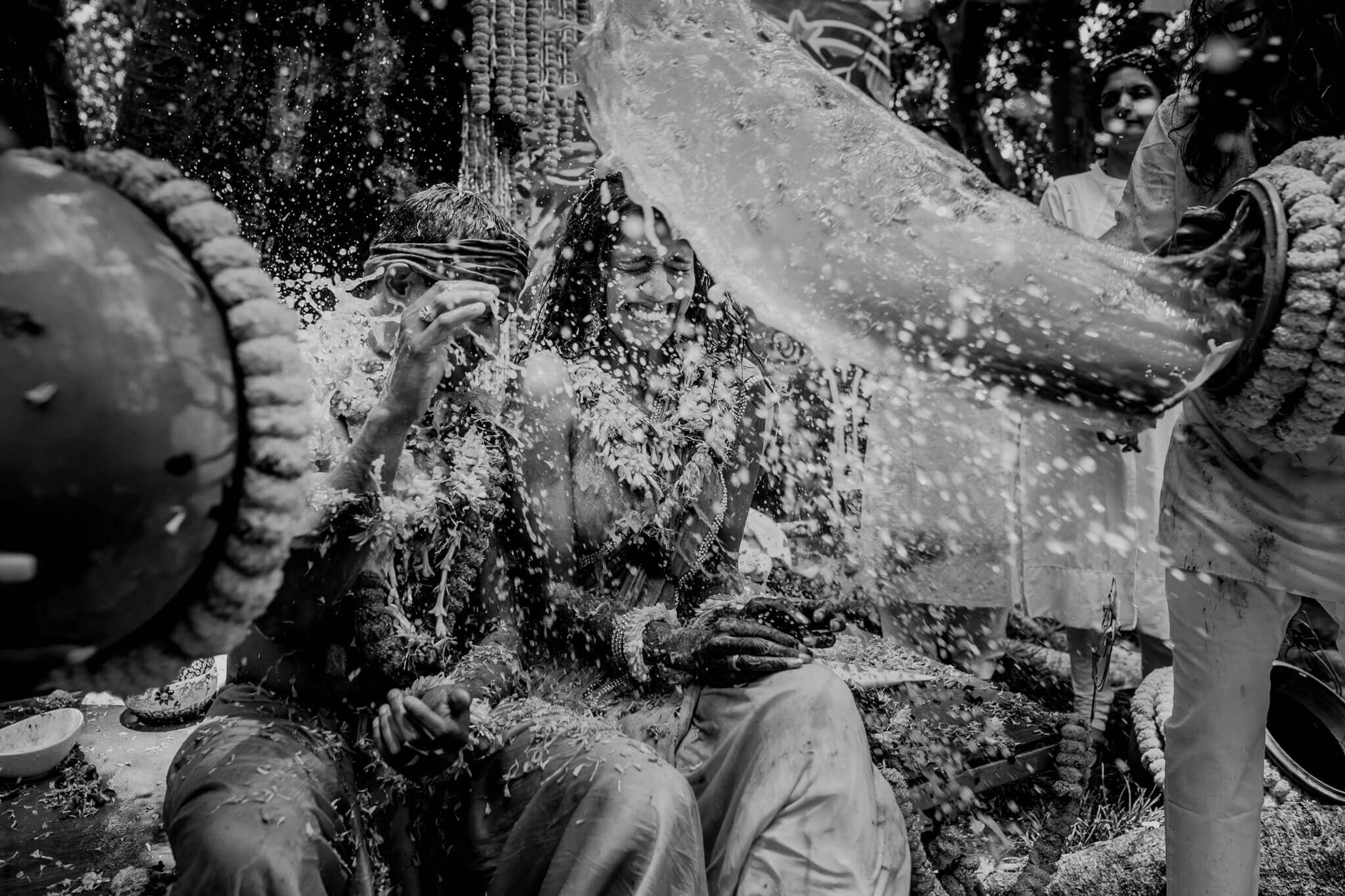 Anu and Raghu getting splashed with water during playful celebration in Nepal, black and white