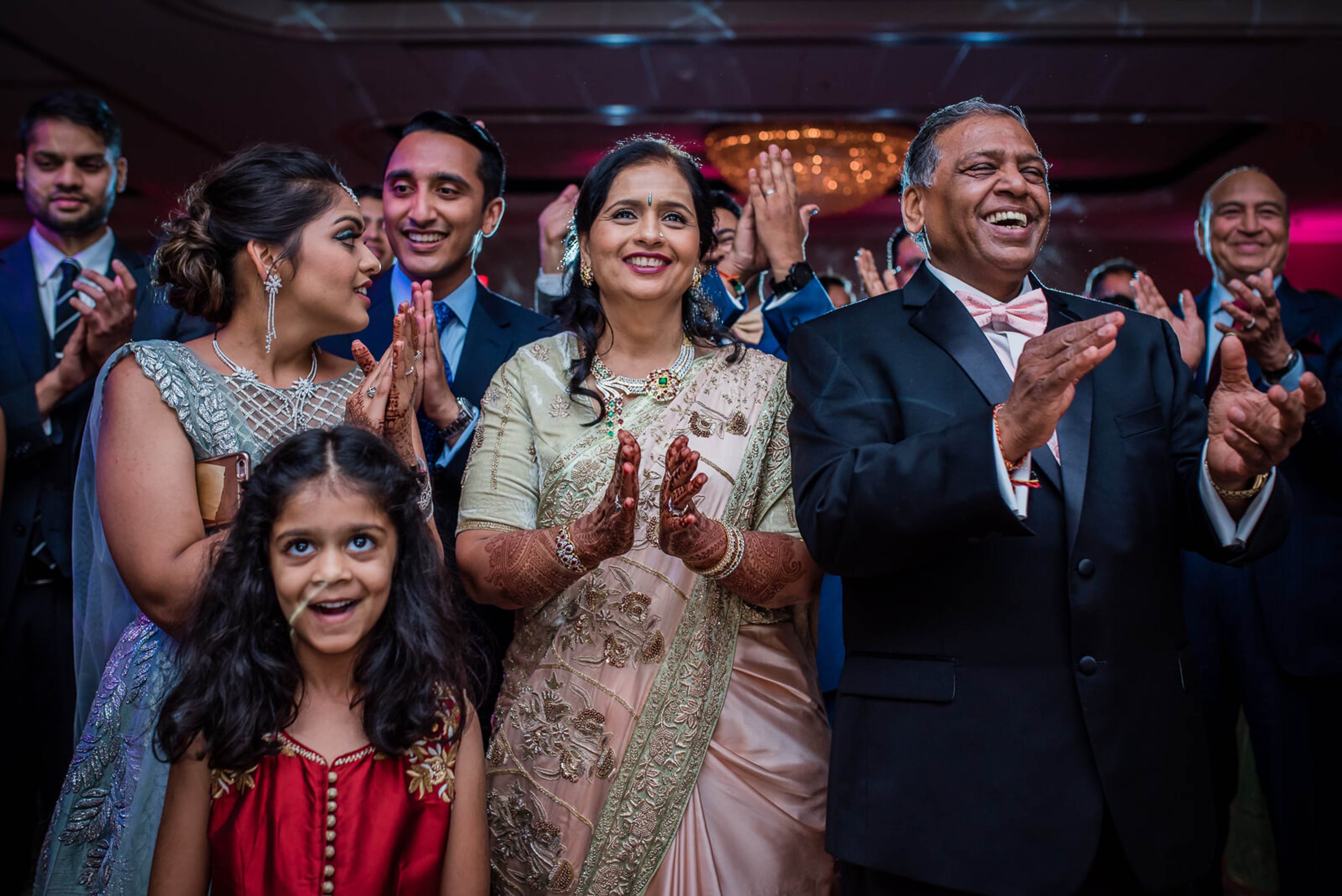 Barkha and Ankit celebrate with family and guests clapping at their New York wedding reception