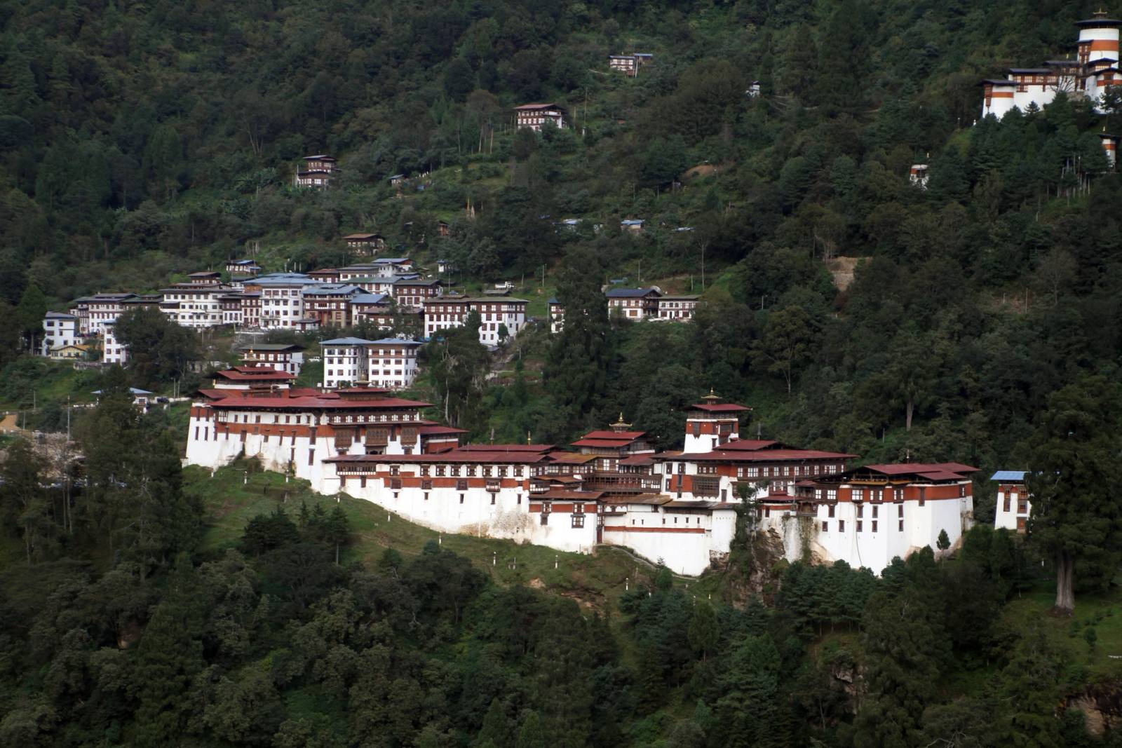 Trongsa Dzong along its ridge below the town, with the Ta Dzong tower on the hill above