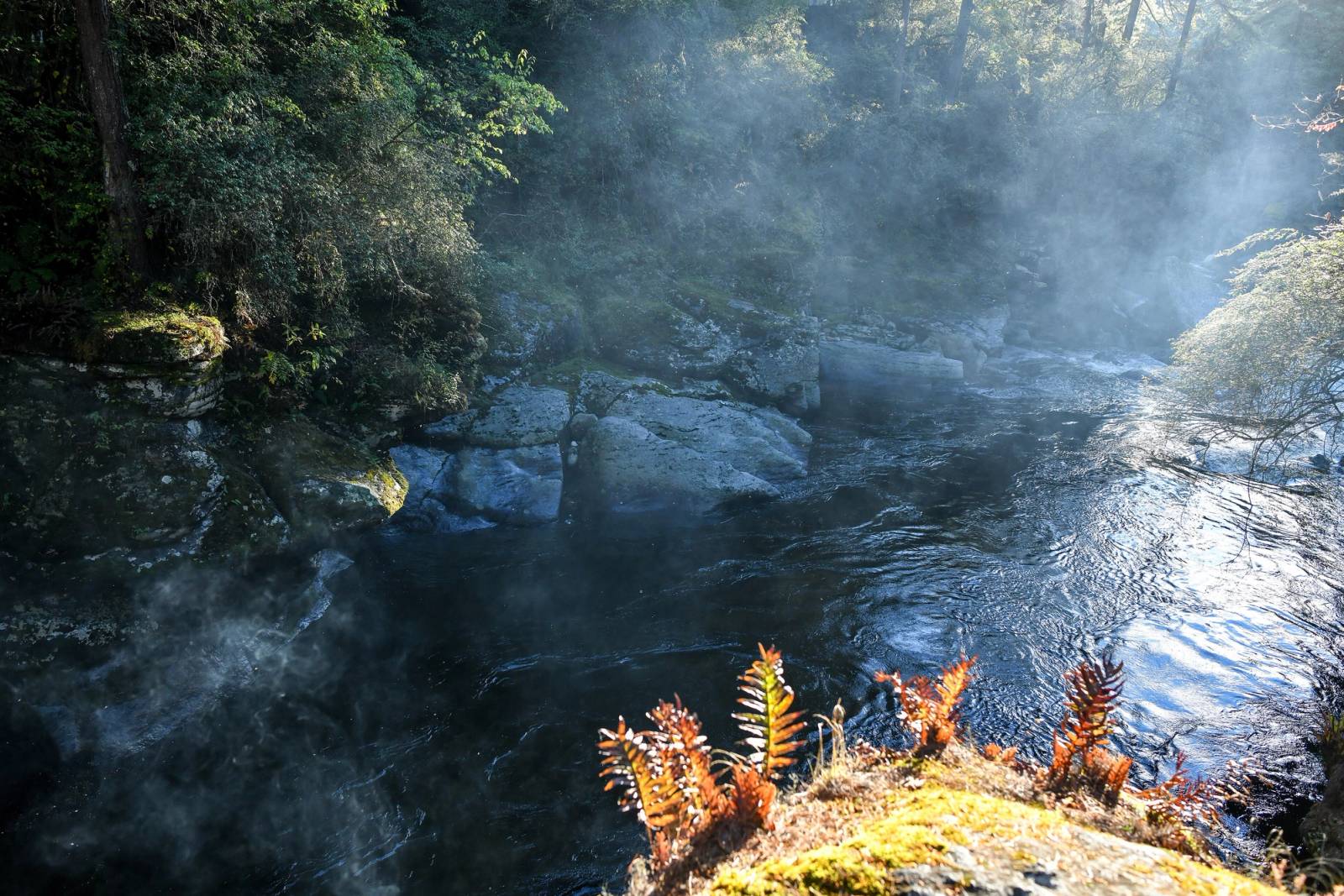 Morning mist rising off the dark pool of Mebar Tsho in the rocky gorge of the Tang Chhu