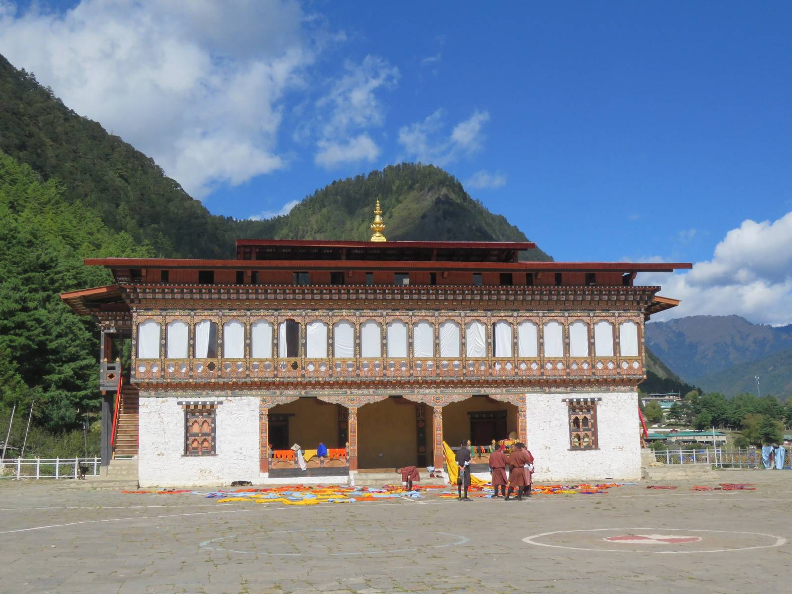 Lhakhang Karpo, the White Temple of Haa, behind its paved courtyard with forested hills