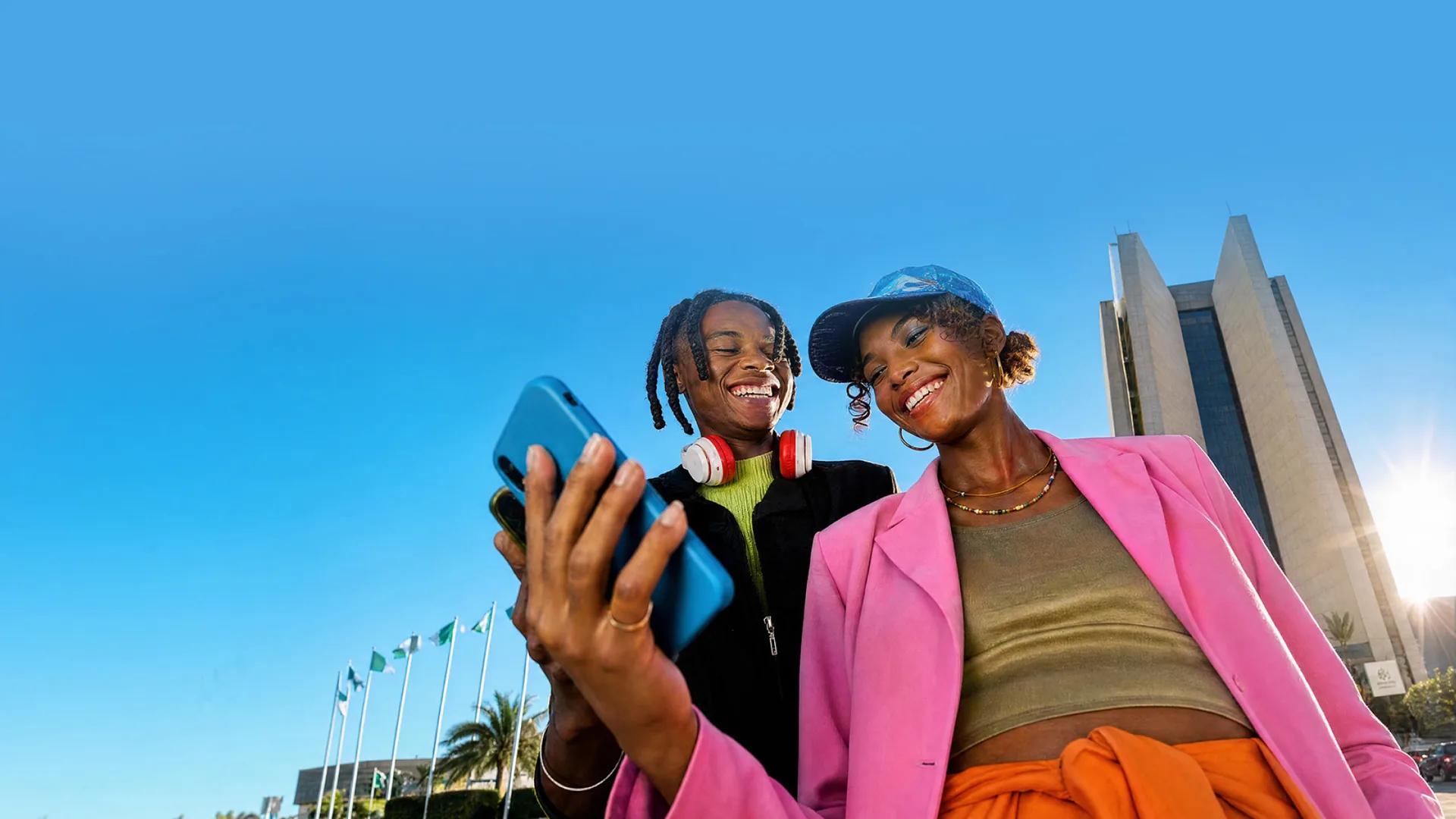 Mular marketing image of two people looking at a phone screen in Abuja, promoting the app.