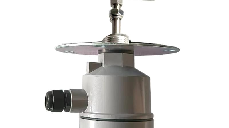 Close-up of three industrial point level switches — a rotary paddle level switch, a vibrating rod level switch and an RF admittance level switch — mounted side by side on a powder storage silo in a chemical plant, showing threaded and flanged process connections