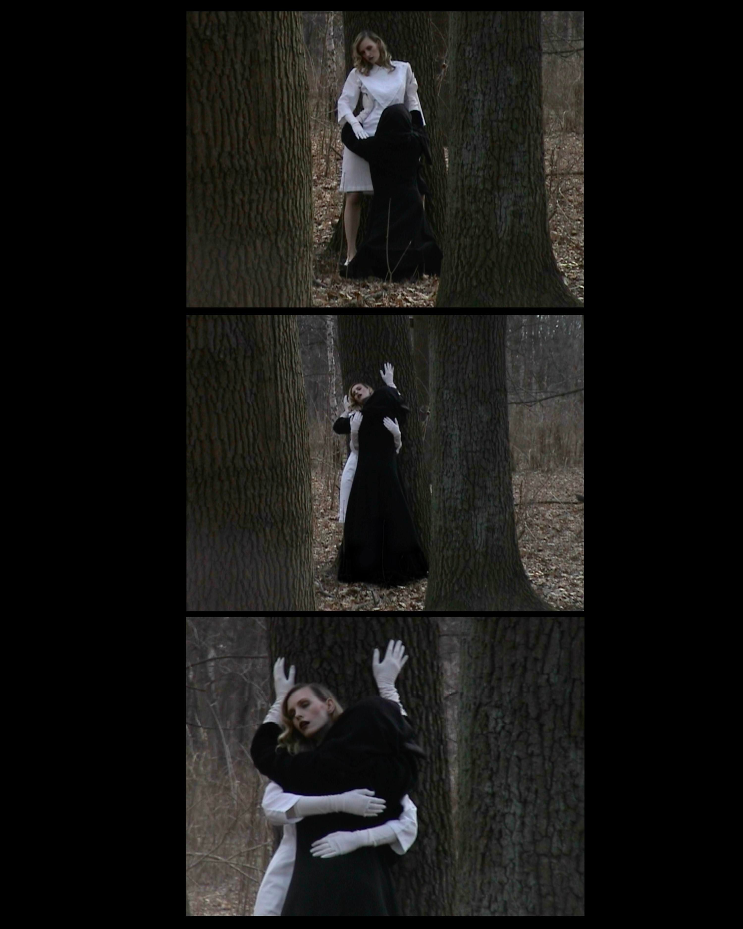 Alt Text: Two figures stand between tall trees — one in white, the other cloaked in black — locked in a tense, ritual-like embrace. SEO Caption: King Kong Magazine editorial — forest tableau of duality in black-and-white styling, photographed by Josephine Meng.