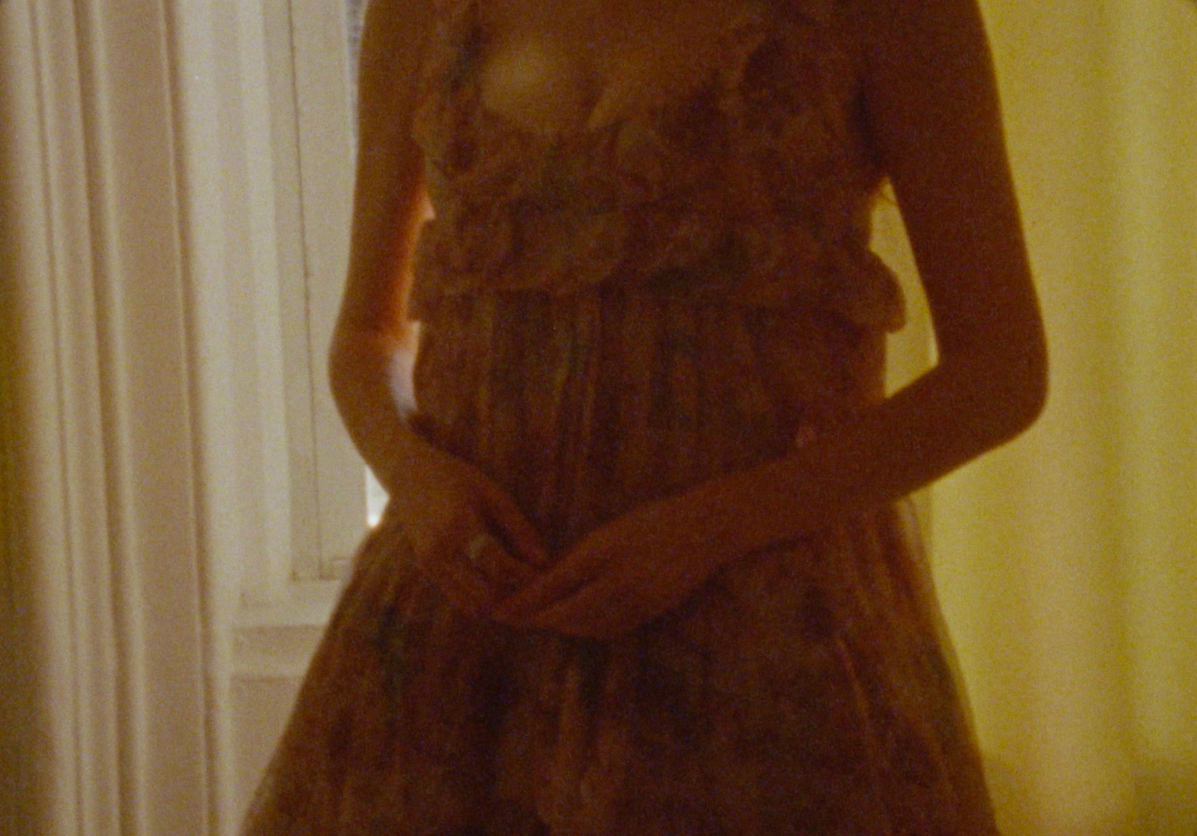 Close-up of Molly Gordon in a delicate floral dress, soft window light revealing sheer ruffles and quiet intimacy — by Sarah Davis.