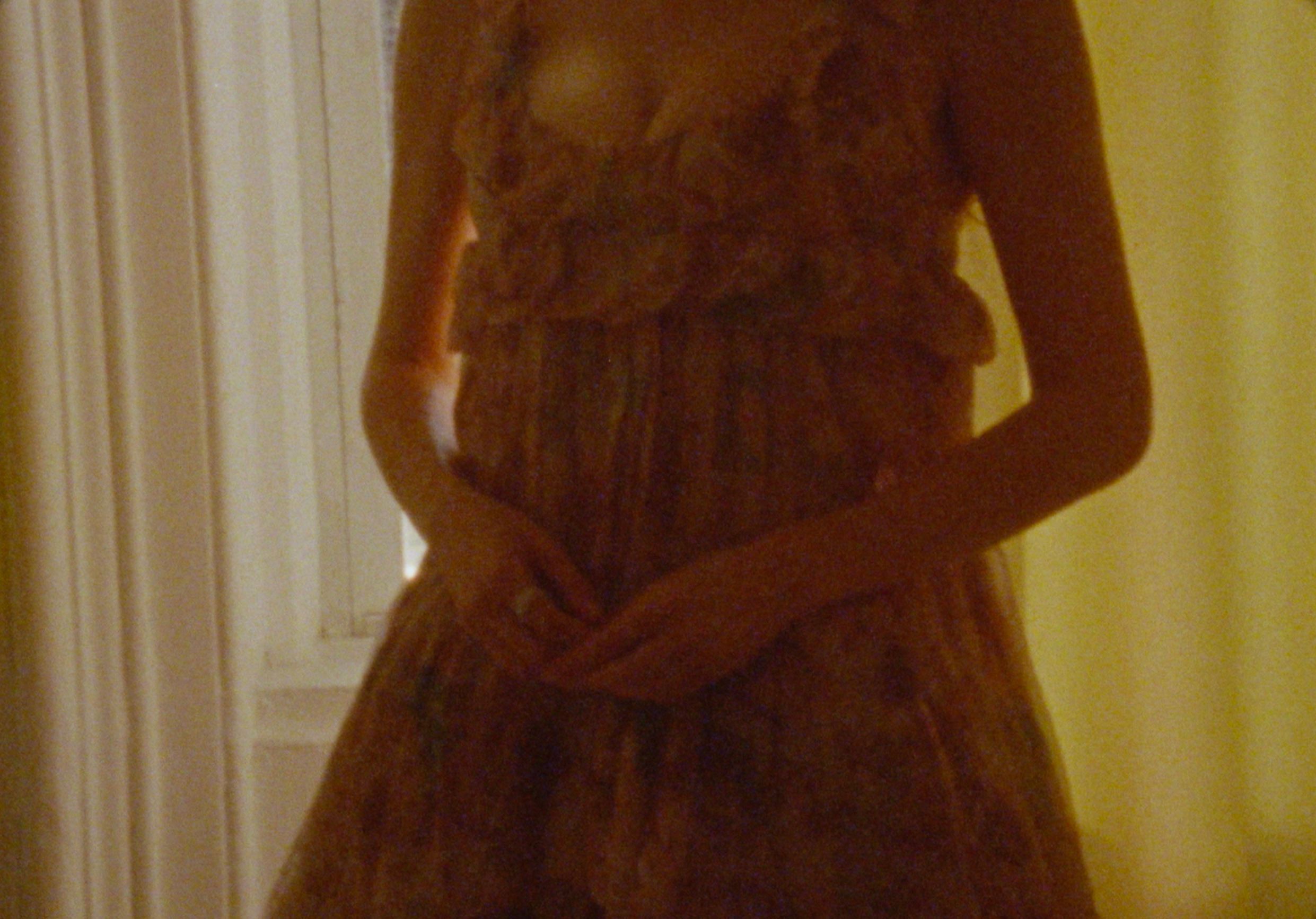 Close-up of Molly Gordon in a delicate floral dress, soft window light revealing sheer ruffles and quiet intimacy — by Sarah Davis.