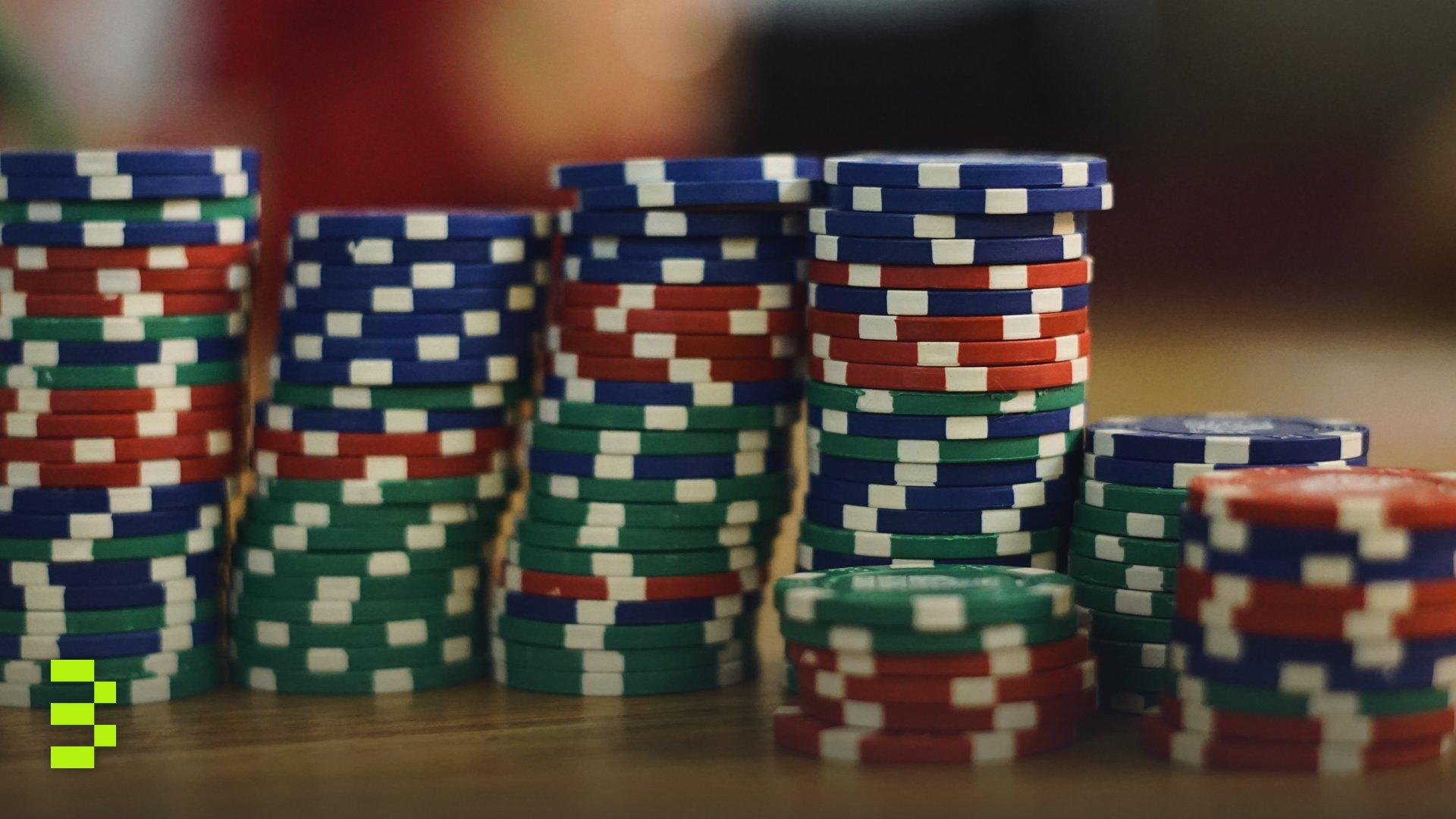 A close-up view of colorful stacked poker chips on a wooden table.