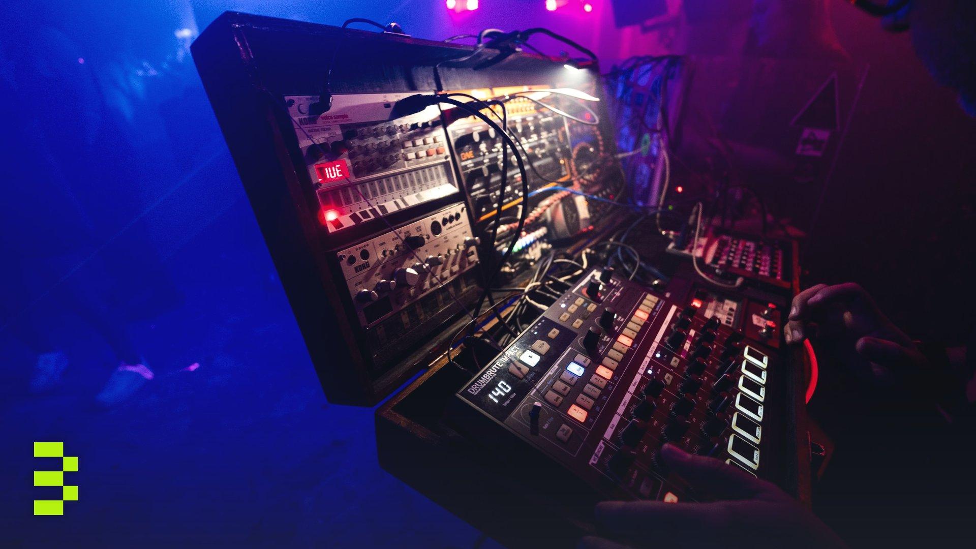 Captivating club scene with a DJ using an electronic mixing console in vibrant lighting.