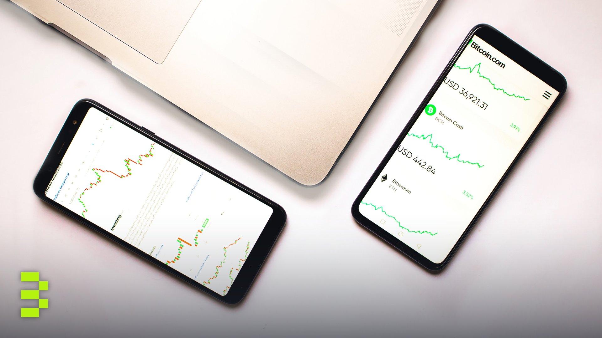 Two smartphones with cryptocurrency data and graphs.