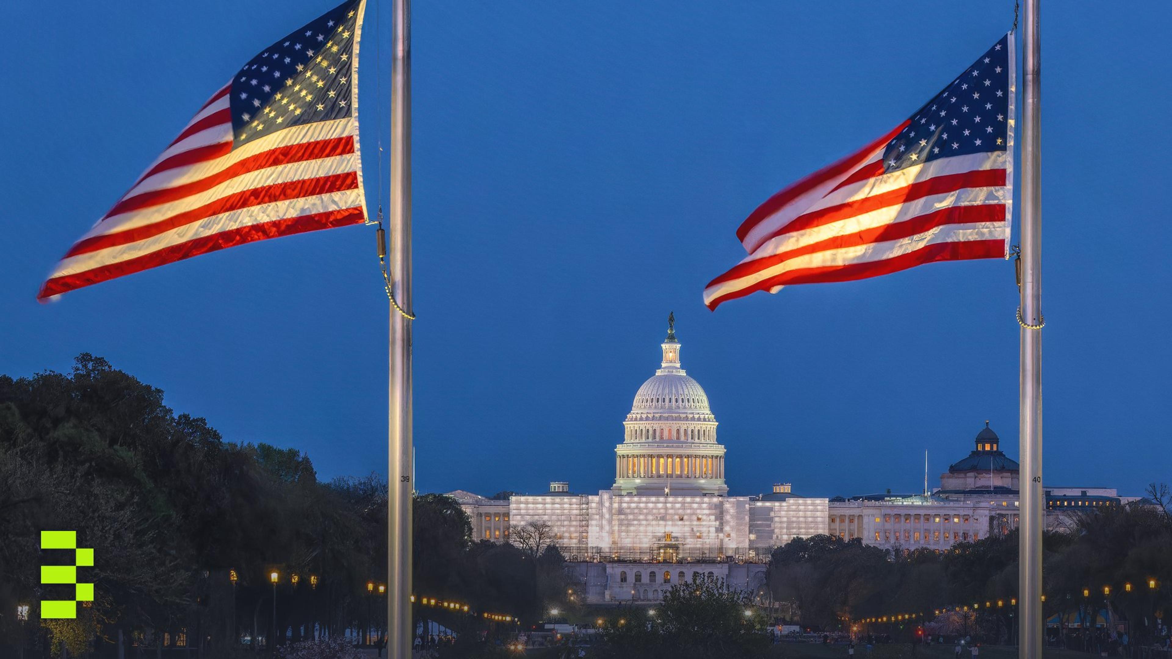 Evening view of the U.S. Capitol in Washington, D.C., with American flags flying in front.