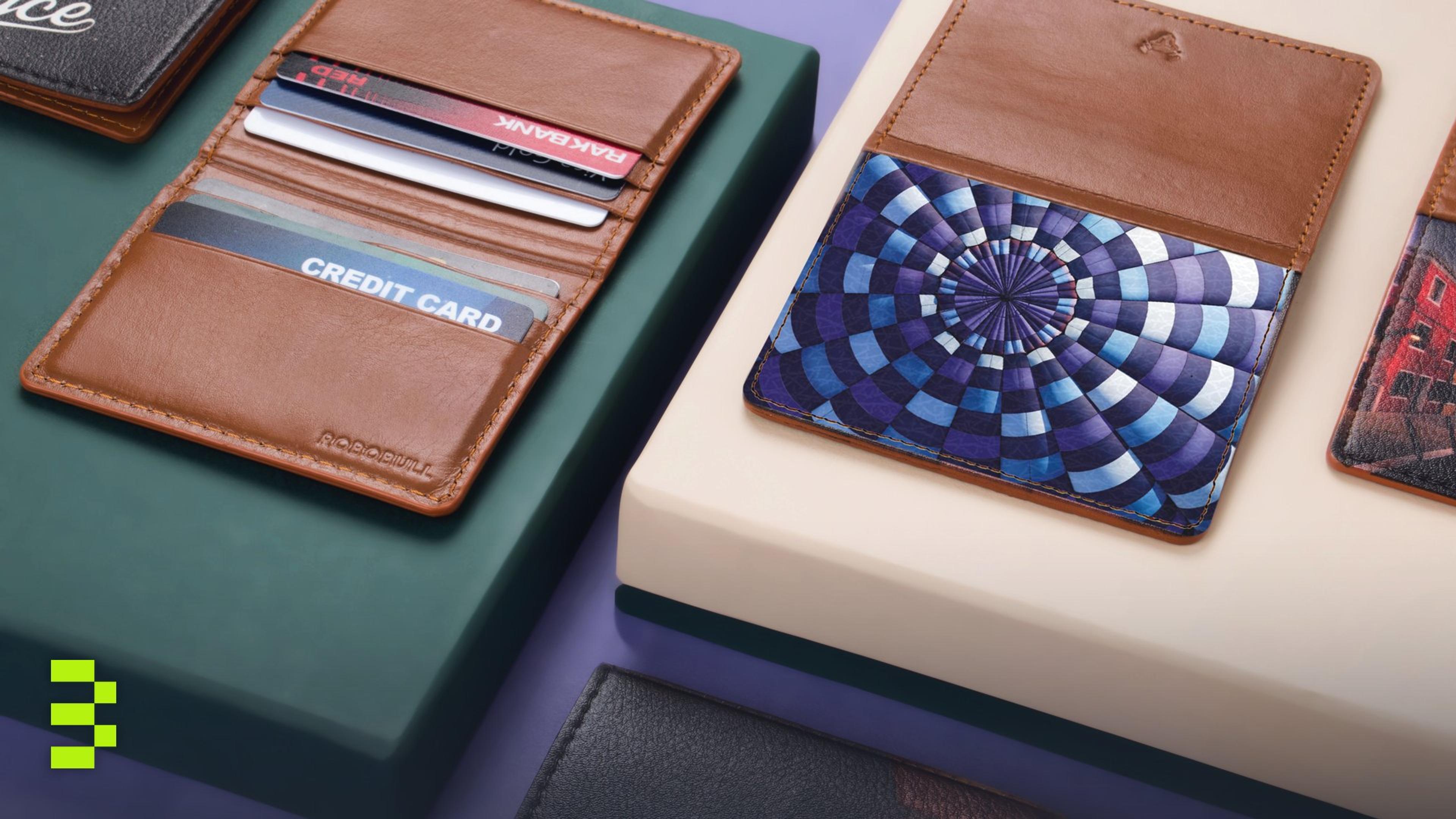 Close-up of assorted leather wallets and cardholders on a modern violet and green background.