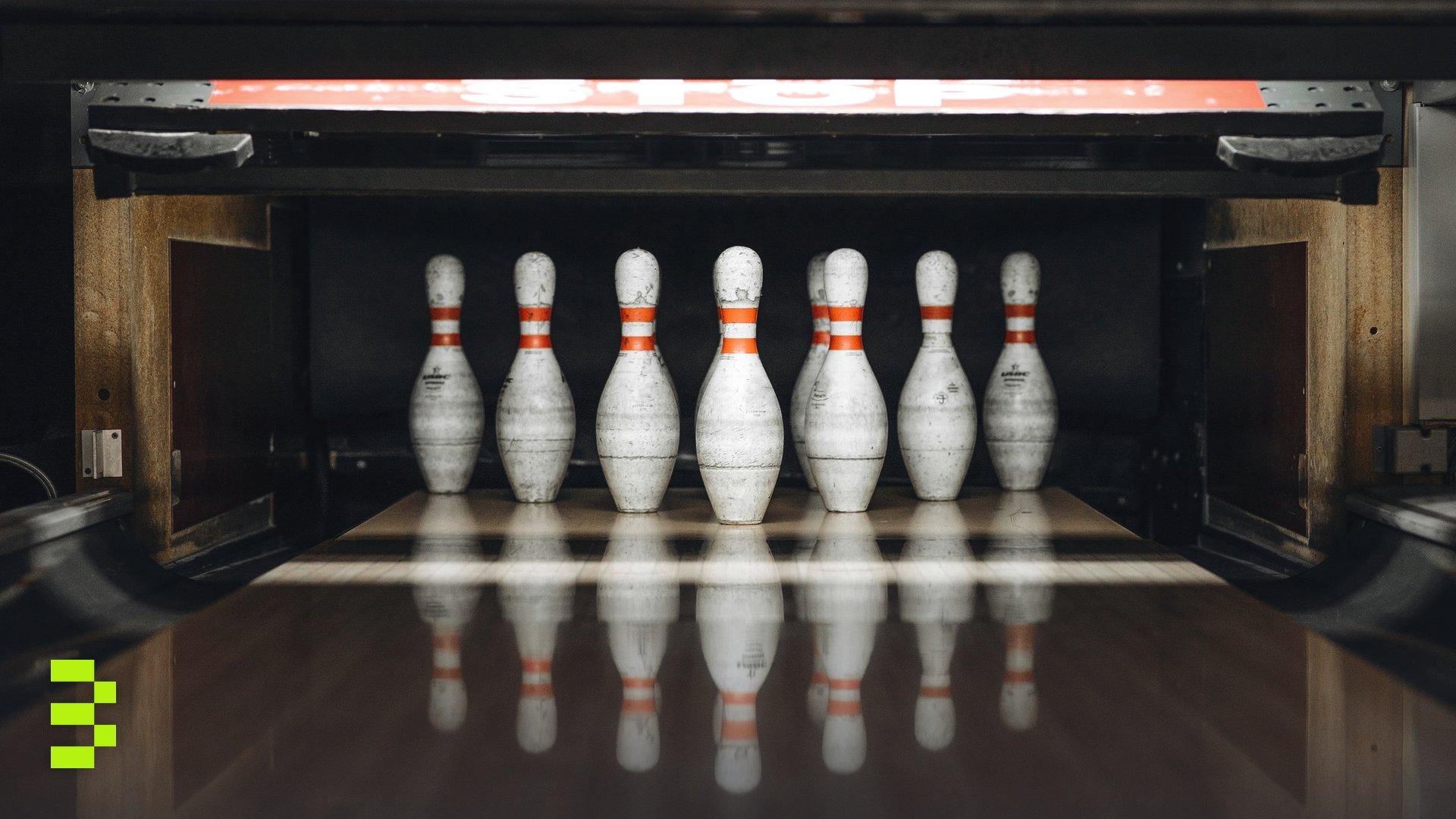 Seven bowling pins arranged in an alley, ready for a game.