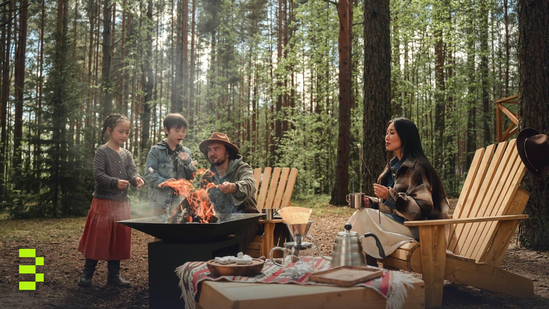 A family enjoying a camping trip with a fire pit in forest surroundings.