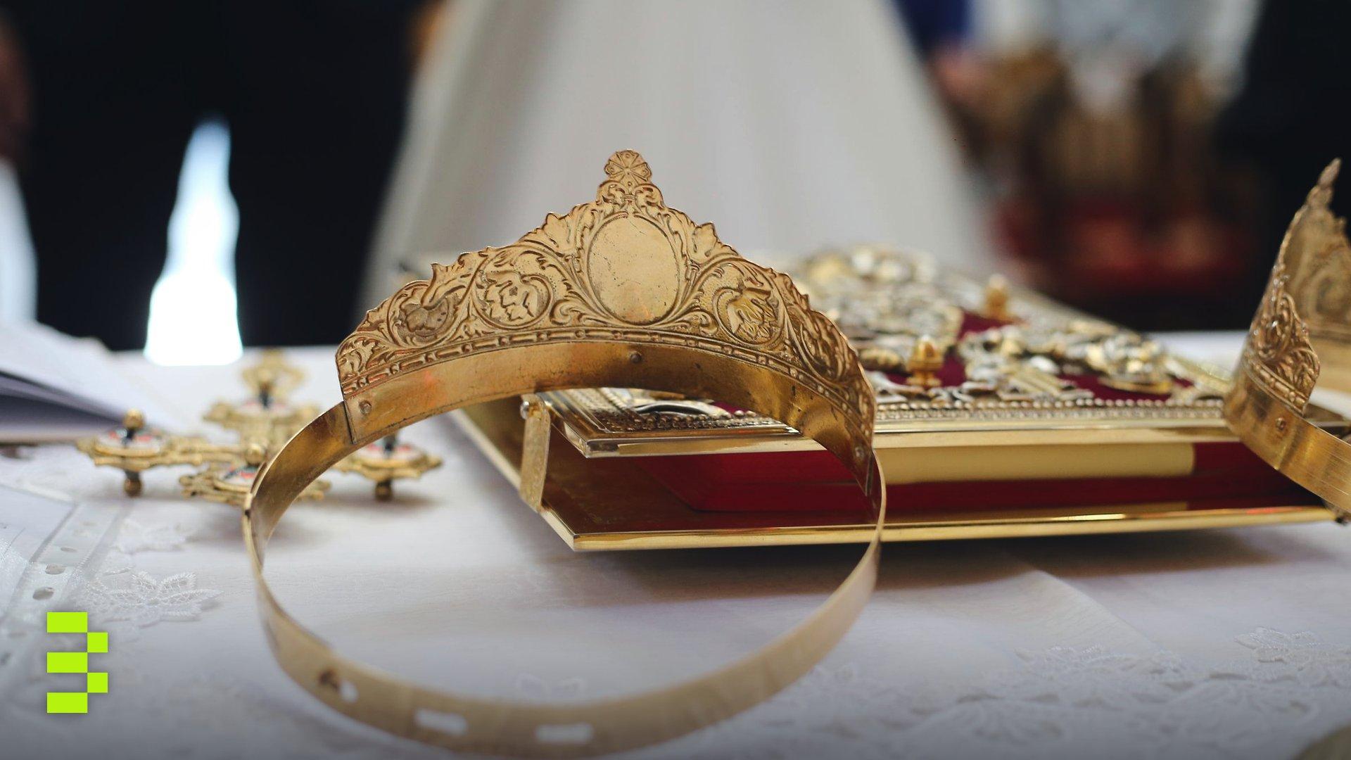 Close-up of ornate golden crowns on a church altar table.