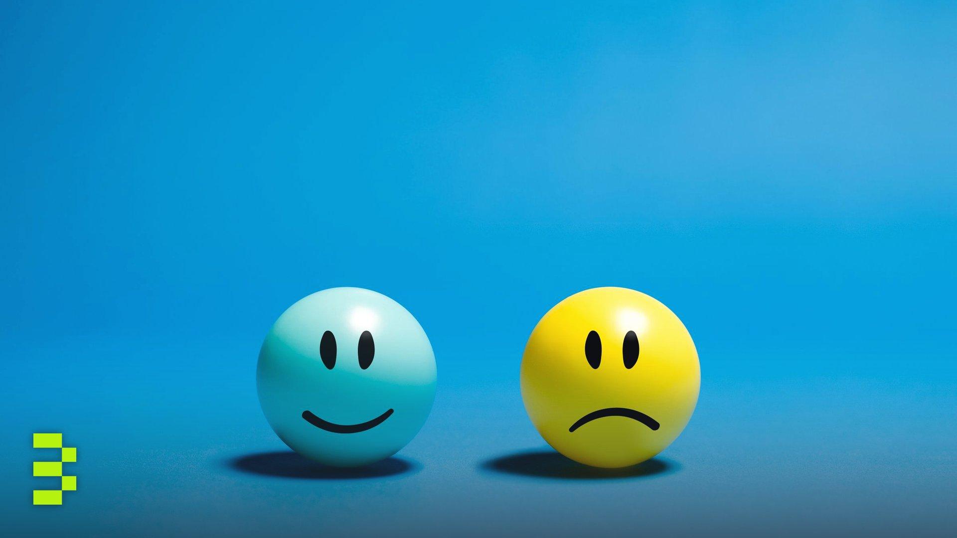 Two smiley balls representing opposite emotions on a blue background.
