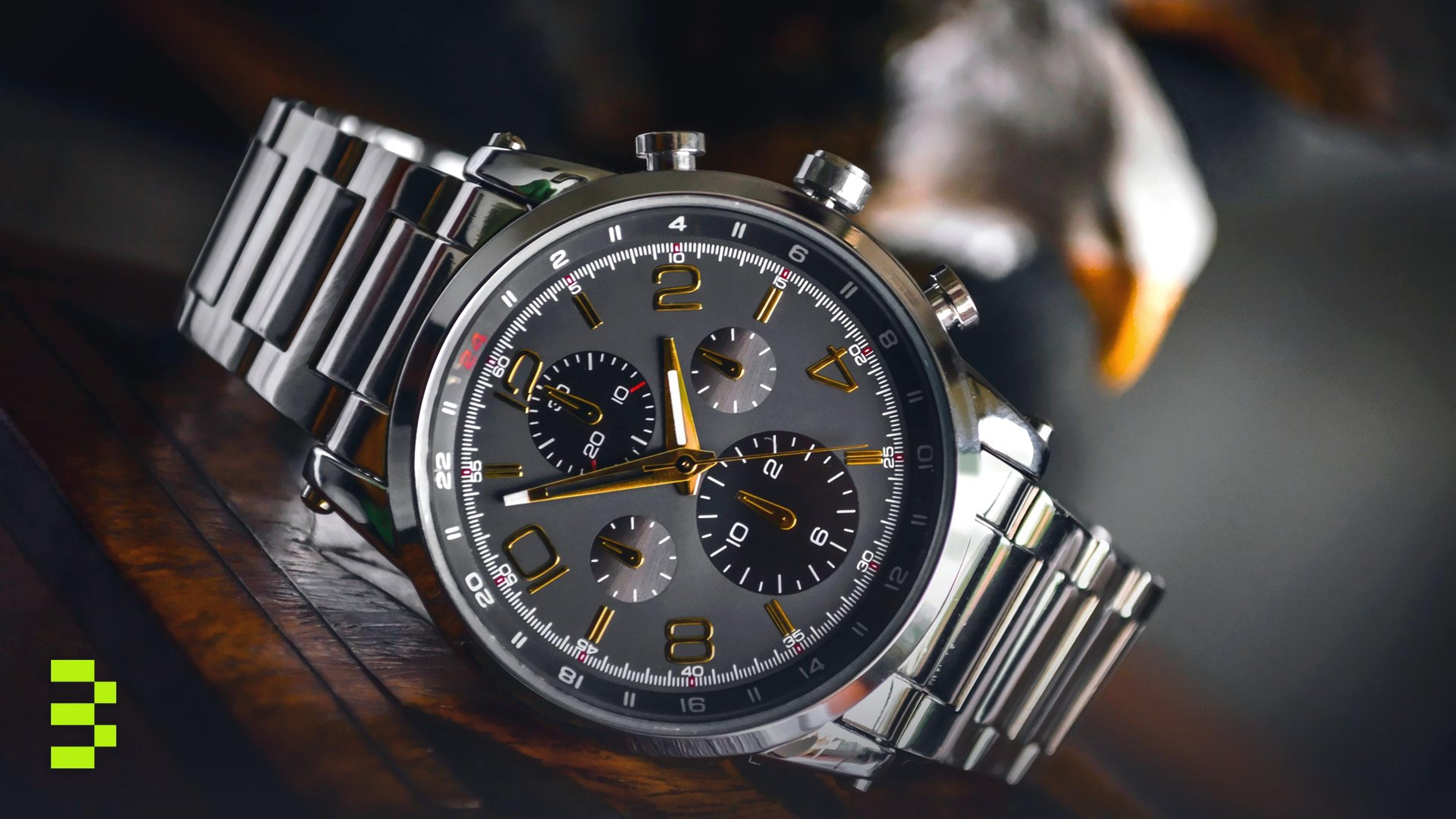 Luxury wristwatch with stainless steel bracelet displayed elegantly on a wooden background.