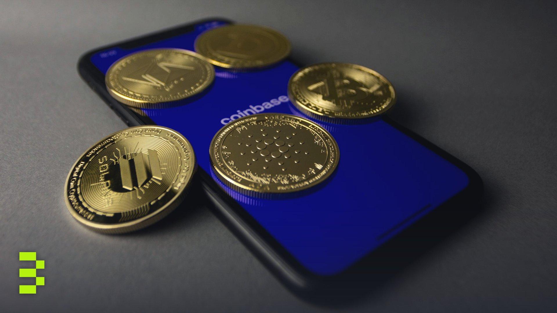 Five cryptocurrency coins displayed on a smartphone with Coinbase app open.