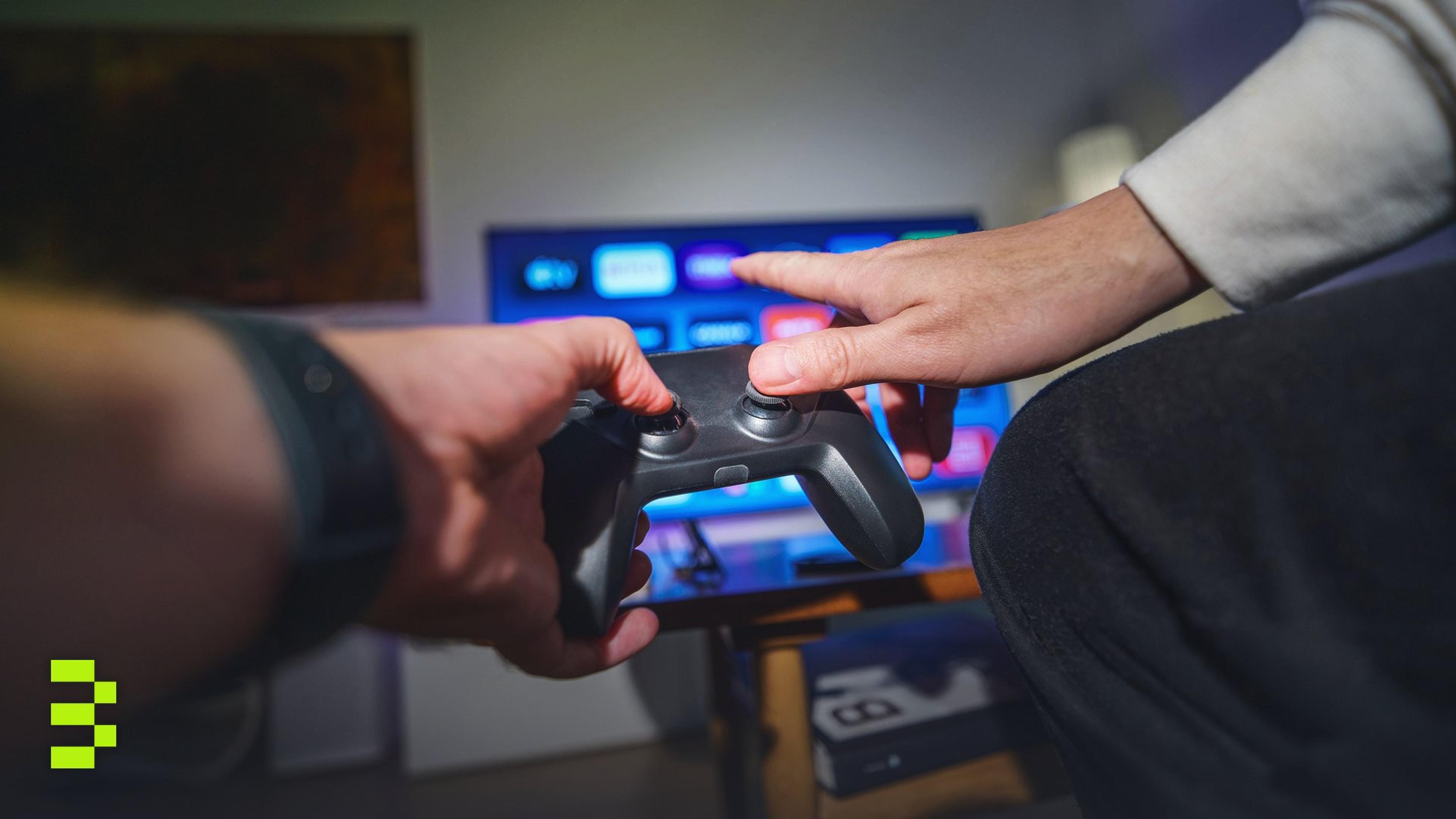 Close-up of hands using a game controller in a cozy living room setting.